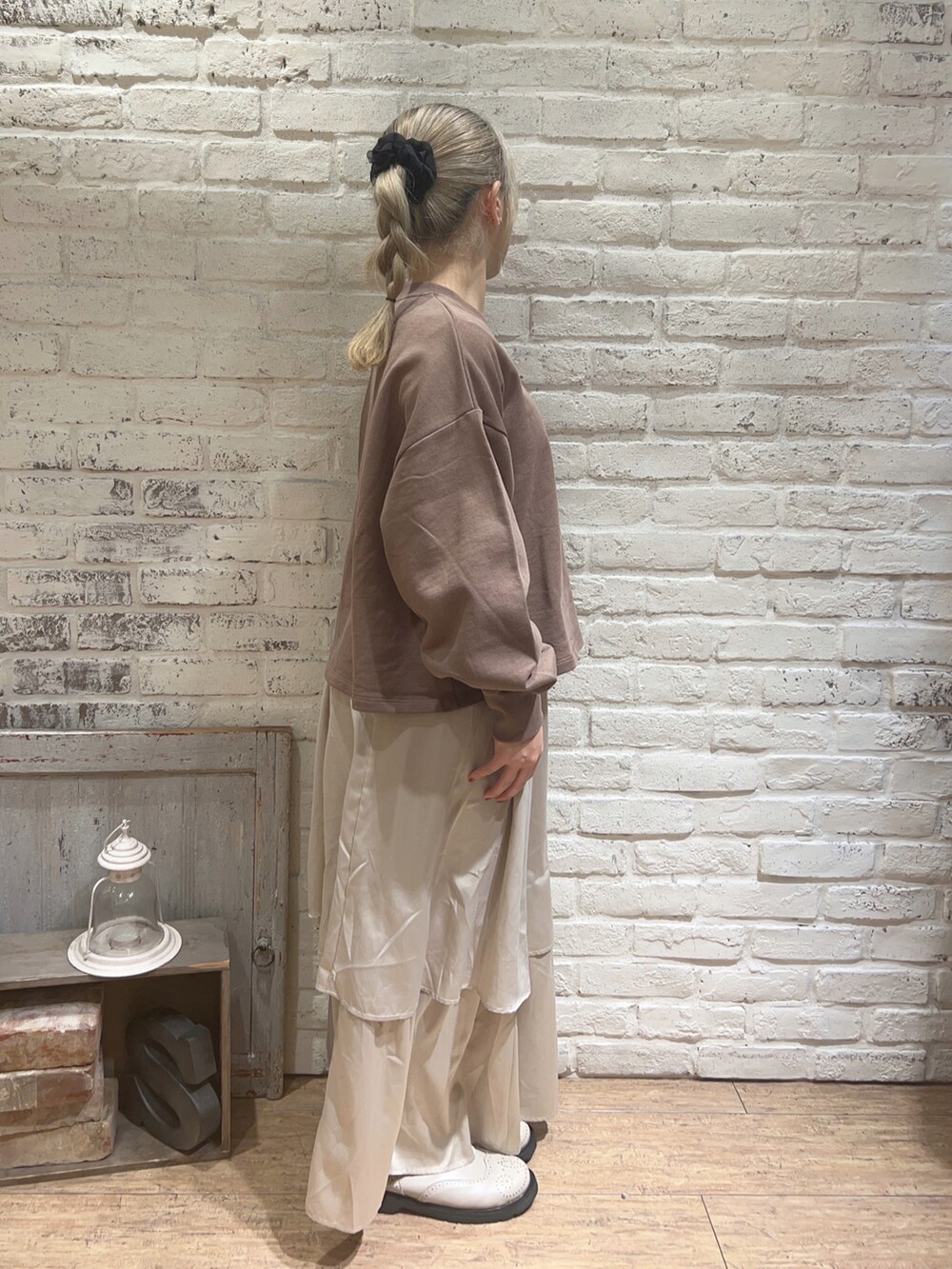 ベージュ系のスカート、ホワイト系のブーツ、ブラウン系のTシャツ/カットソーを着用したレディースの冬コーディネートの2枚目の写真