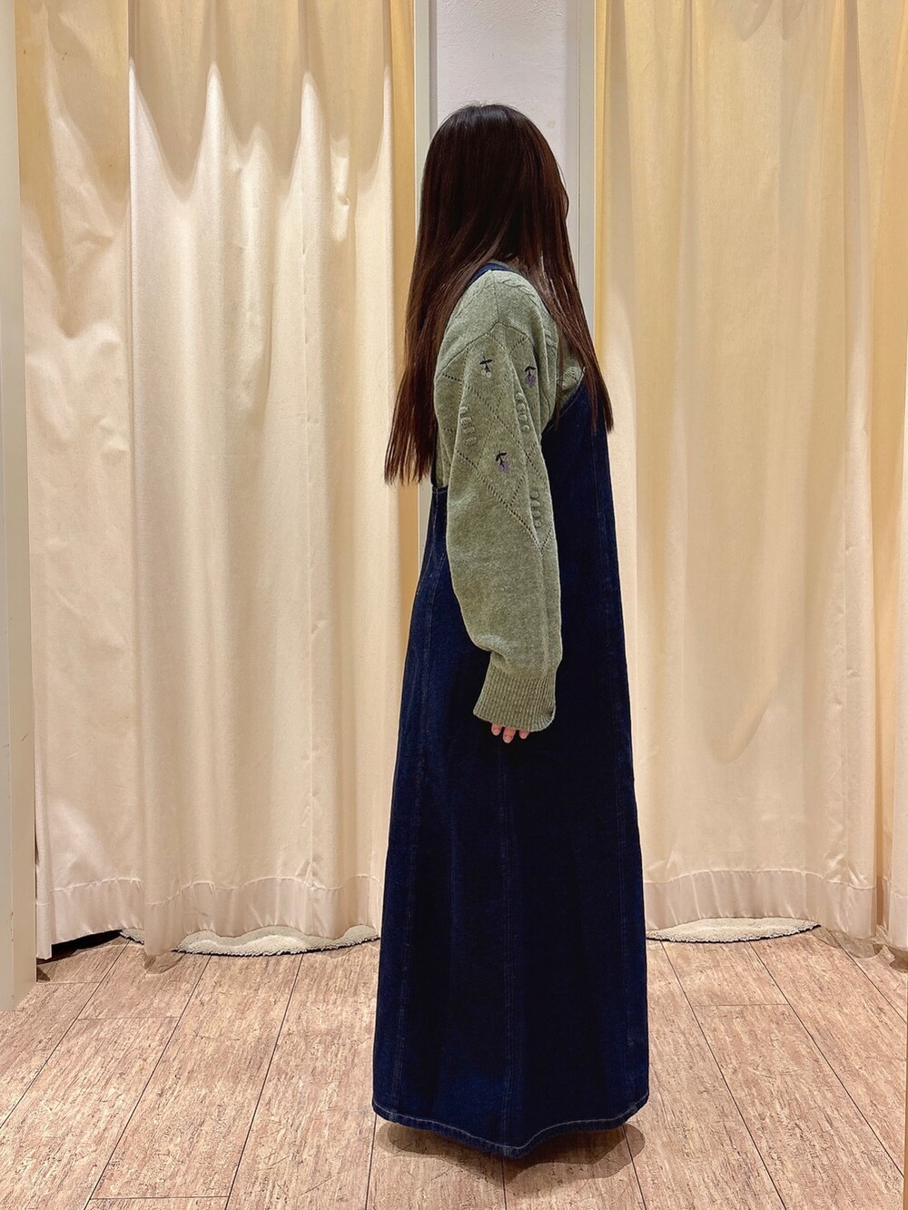 ブルー系のワンピース、グリーン系のニット/セーターを着用したレディースの秋コーディネートの2枚目の写真