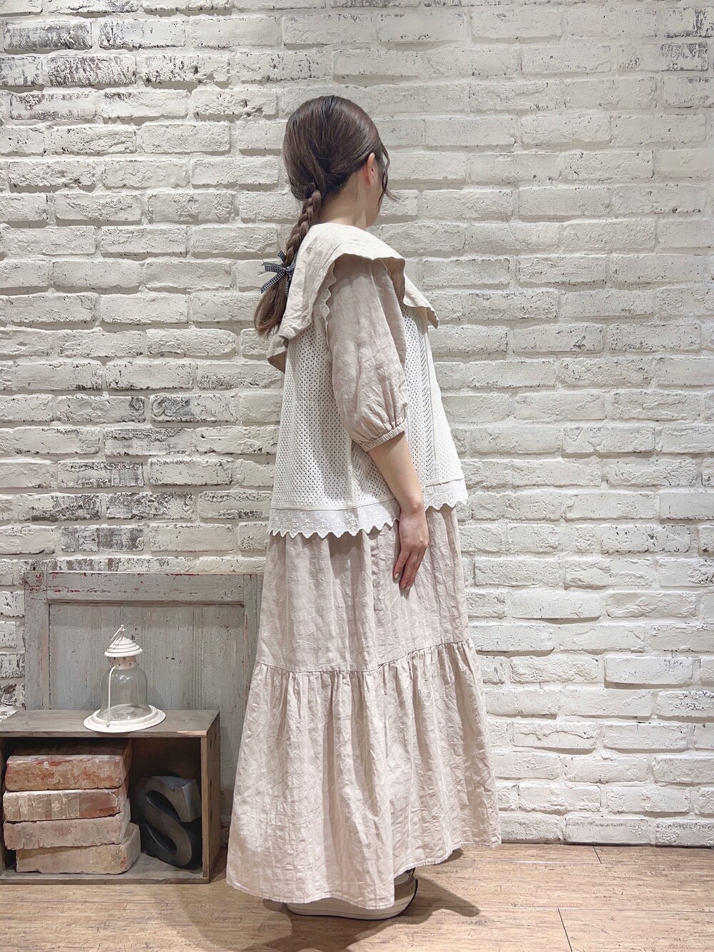 ベージュ系のワンピース、ホワイト系のベストを着用したレディースの夏コーディネートの2枚目の写真