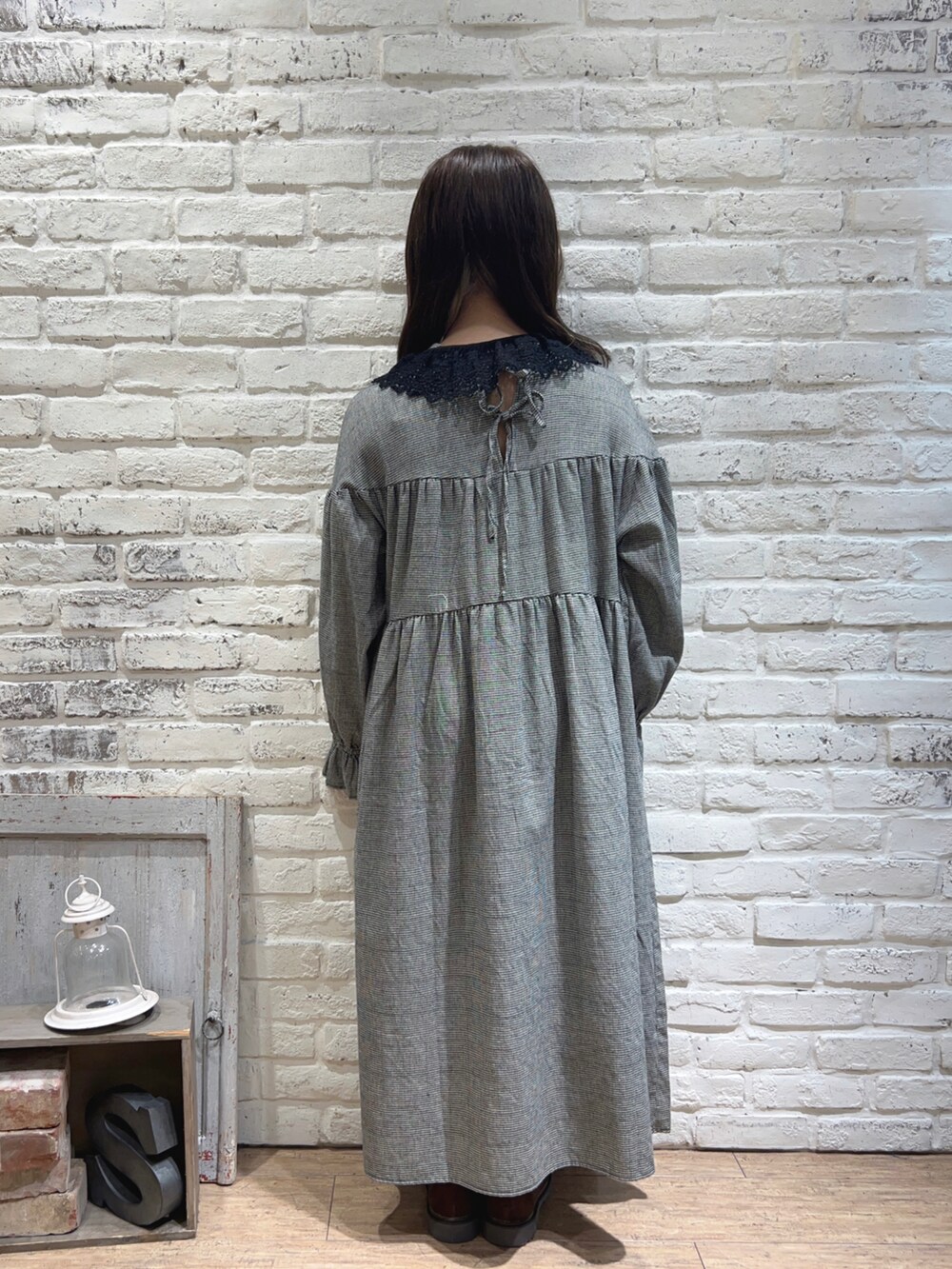 ホワイト系のワンピース、ブラウン系のドレスシューズ、ベージュ系のネックレスを着用したレディースの秋コーディネートの3枚目の写真