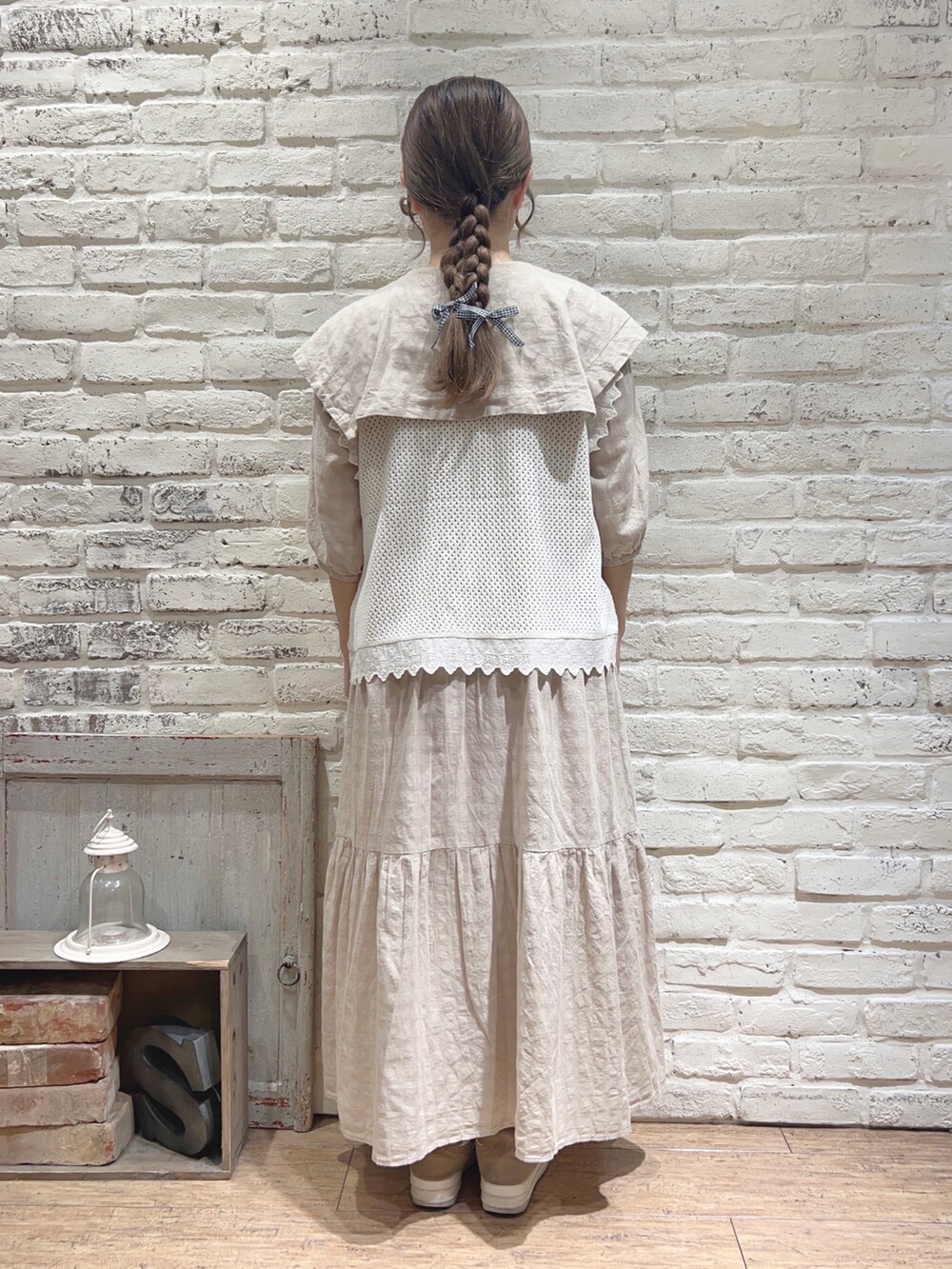 ベージュ系のワンピース、ホワイト系のベストを着用したレディースの夏コーディネートの3枚目の写真