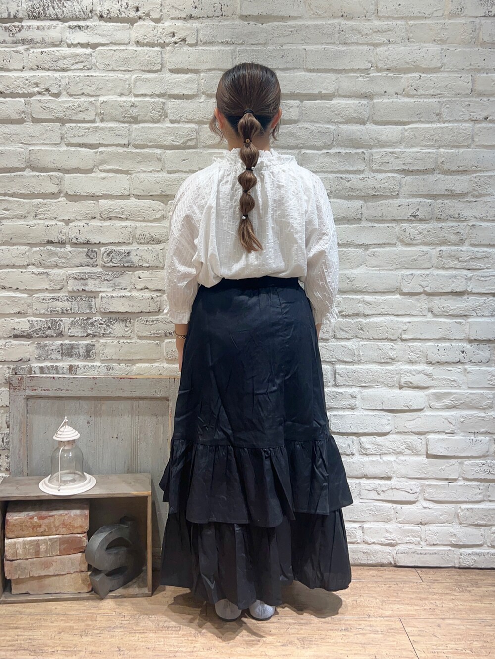 ホワイト系のTシャツ/カットソー、ブラック系のスカート、ブラック系のハンドバッグを着用したレディースの秋コーディネートの3枚目の写真