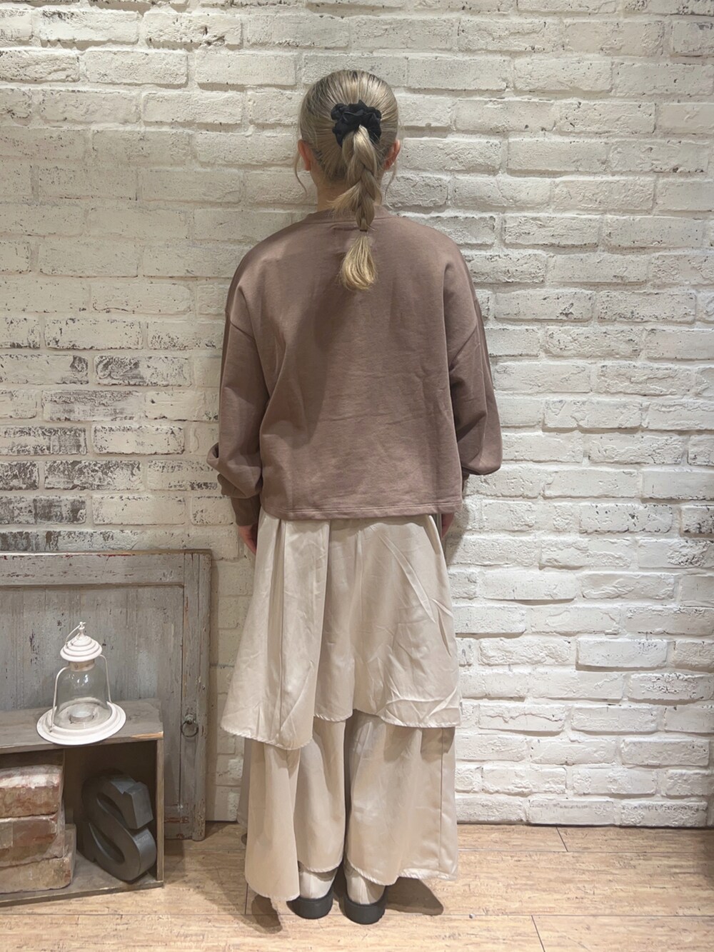 ベージュ系のスカート、ホワイト系のブーツ、ブラウン系のTシャツ/カットソーを着用したレディースの冬コーディネートの3枚目の写真