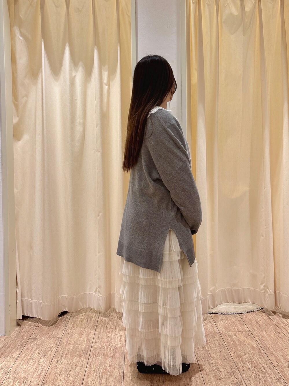 ホワイト系のスカート、ホワイト系のシャツ/ブラウス、グレー系のニット/セーターを着用したレディースの秋コーディネートの2枚目の写真