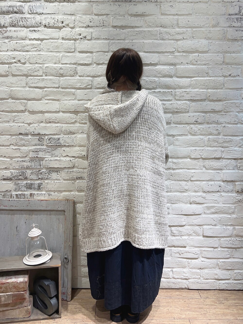 ブルー系のワンピース、ベージュ系のカーディガン/ボレロ、ブラック系のサンダルを着用したレディースの秋コーディネートの3枚目の写真