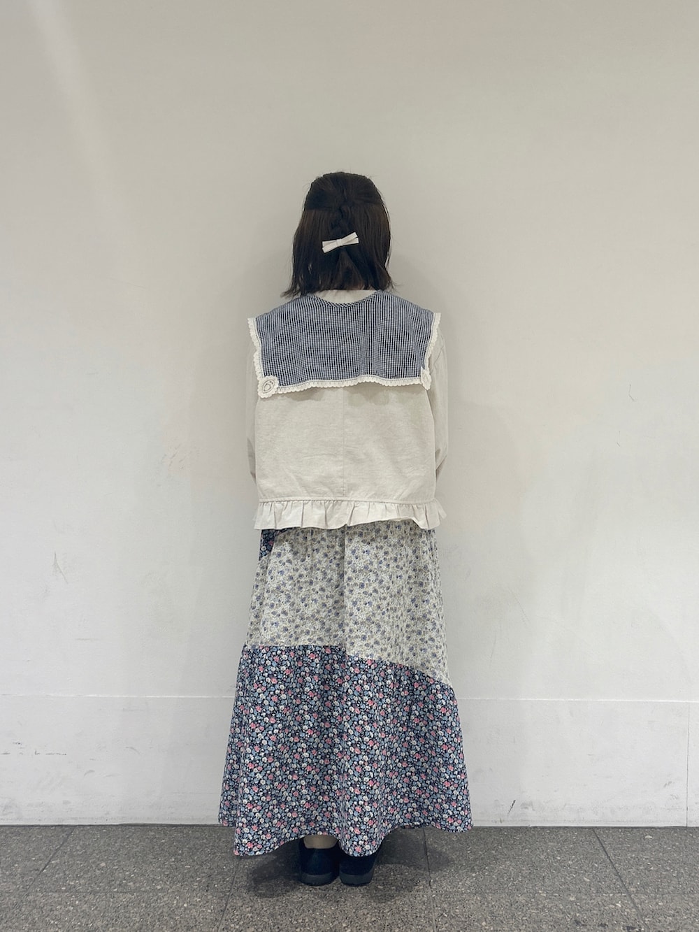 ホワイト系のノーカラージャケット、ブルー系のスカートを着用したレディースの春コーディネートの3枚目の写真