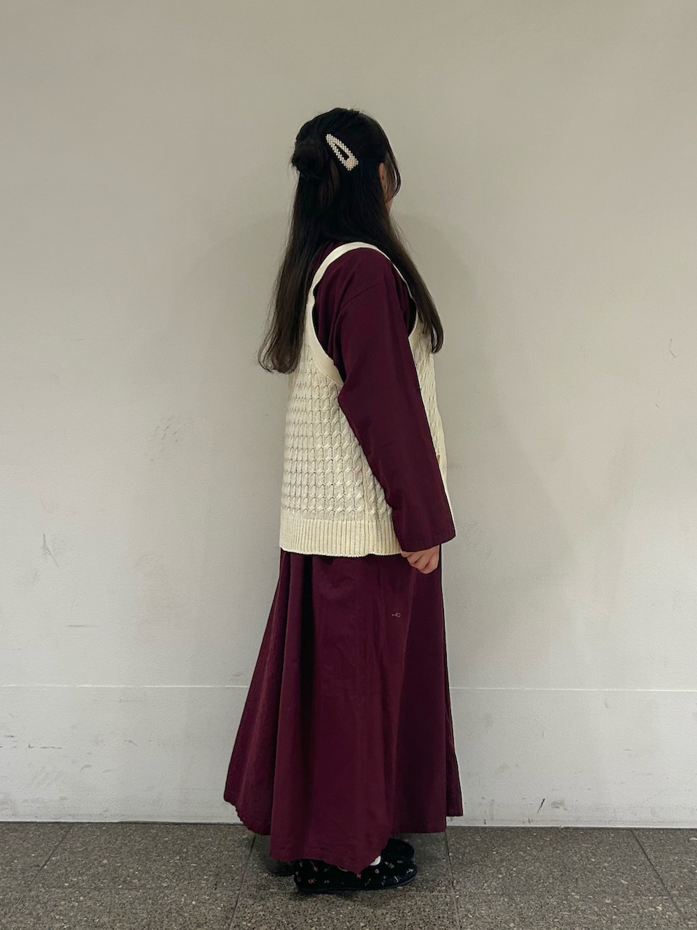 ホワイト系のベスト、パープル系のワンピース、ブラック系のドレスシューズを着用したレディースの秋コーディネートの2枚目の写真