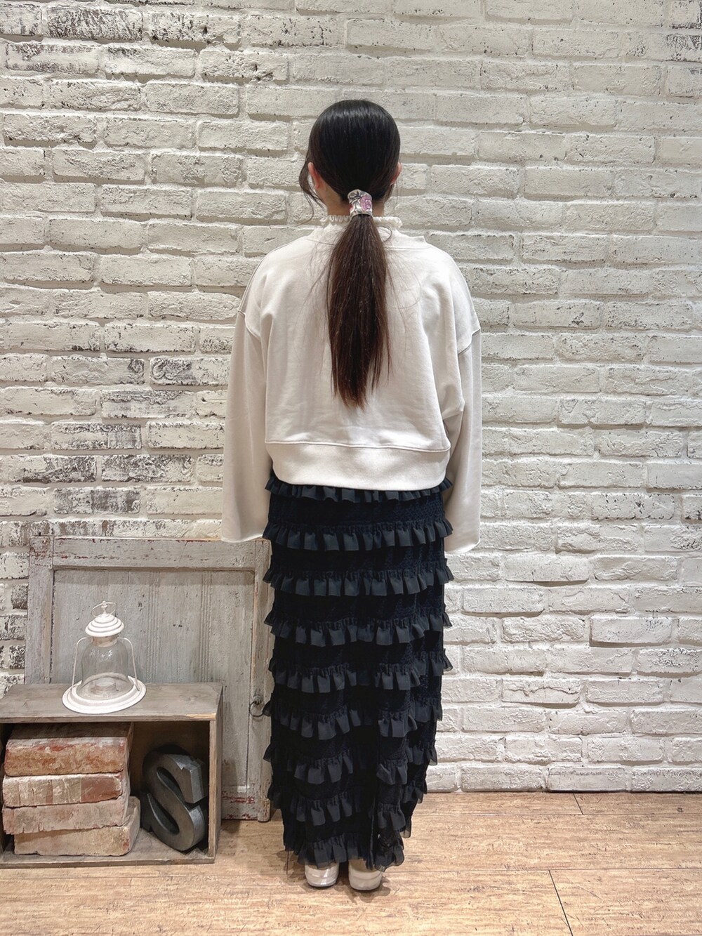 ブラック系のスカート、ホワイト系のTシャツ/カットソー、ブラック系のハンドバッグを着用したレディースの冬コーディネートの3枚目の写真