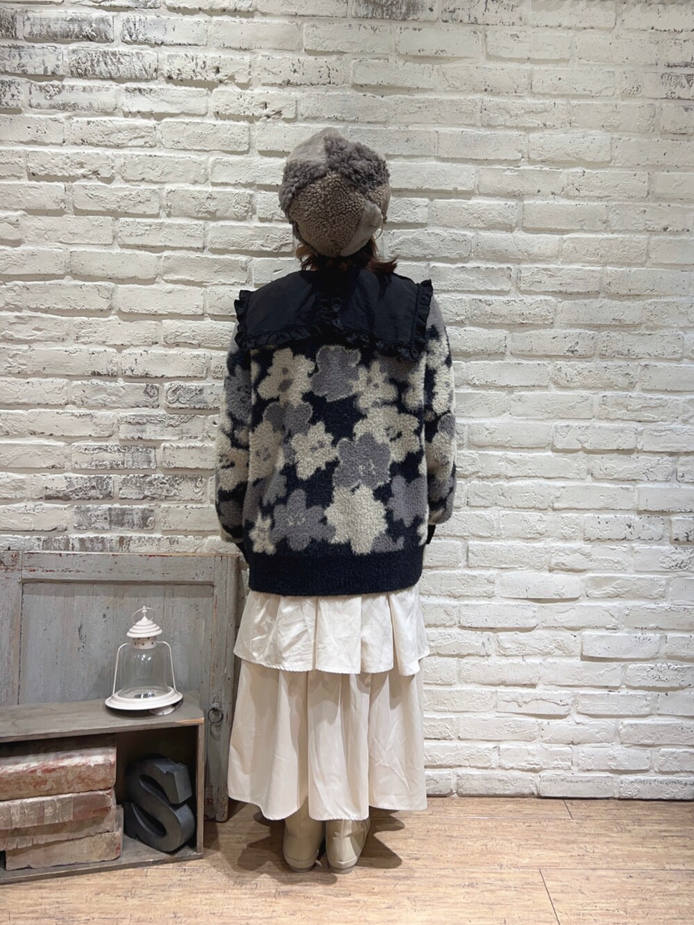 ホワイト系のスカート、ブラック系のシャツ/ブラウス、ブラック系のカーディガン/ボレロを着用したレディースの冬コーディネートの3枚目の写真