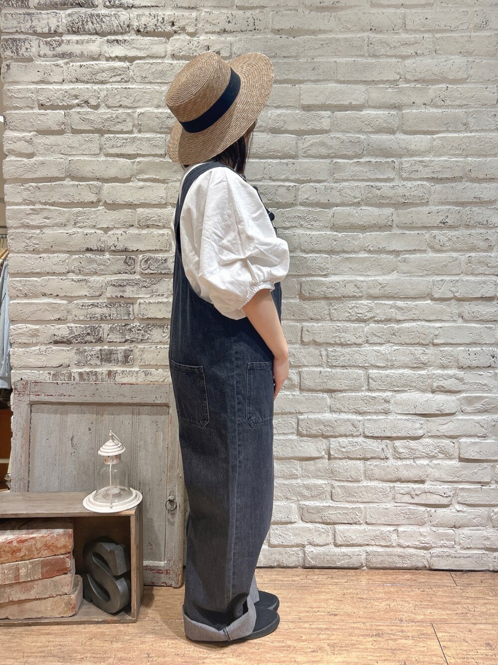 ホワイト系のTシャツ/カットソー、ブラック系のその他パンツ、ブラウン系のハットを着用したレディースの春コーディネートの2枚目の写真