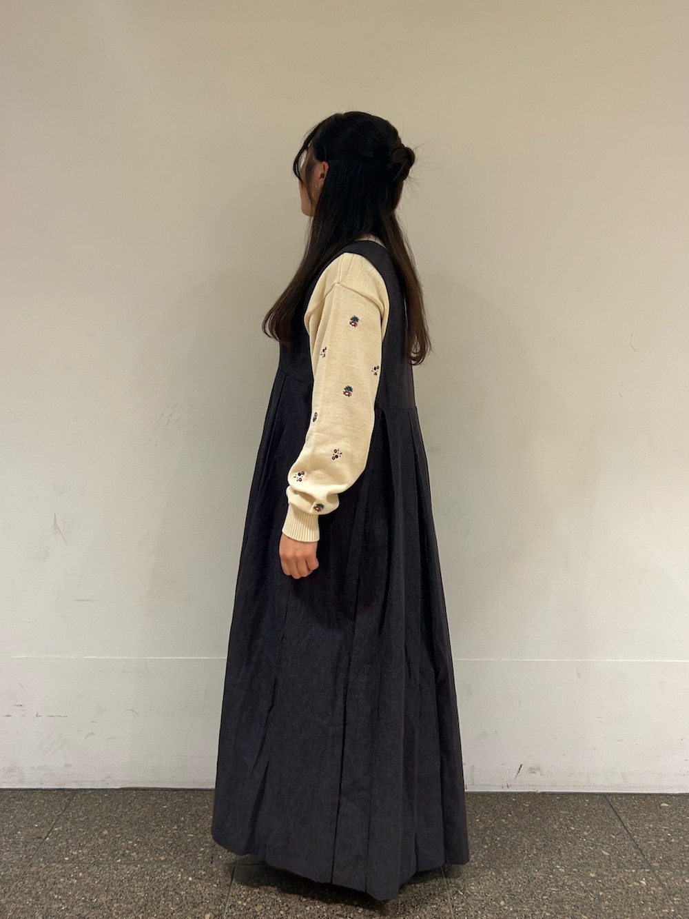 グレー系のワンピース、ホワイト系のカーディガン/ボレロ、ブラック系のドレスシューズを着用したレディースの秋コーディネートの2枚目の写真