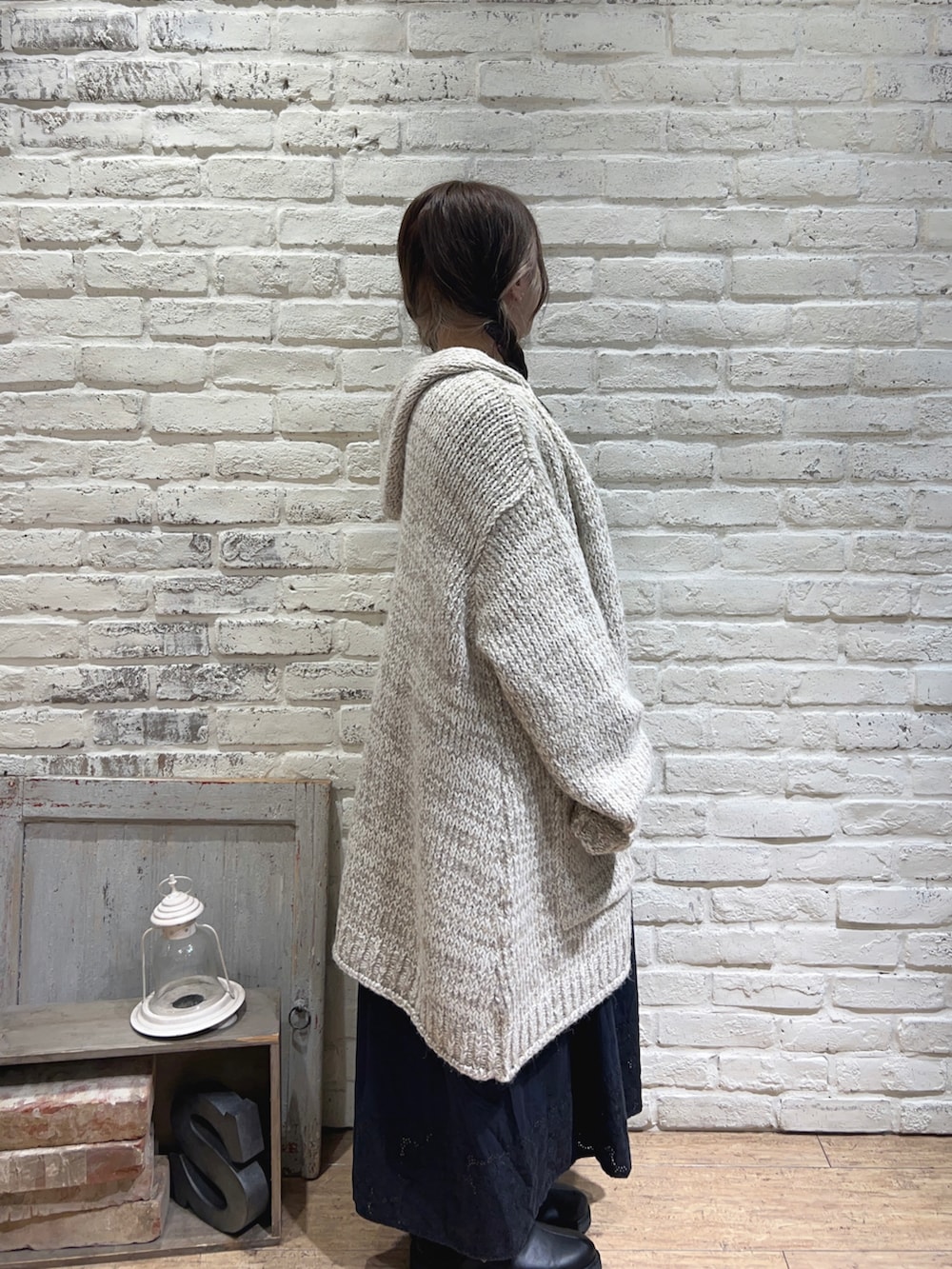 ブルー系のワンピース、ベージュ系のカーディガン/ボレロ、ブラック系のサンダルを着用したレディースの秋コーディネートの2枚目の写真