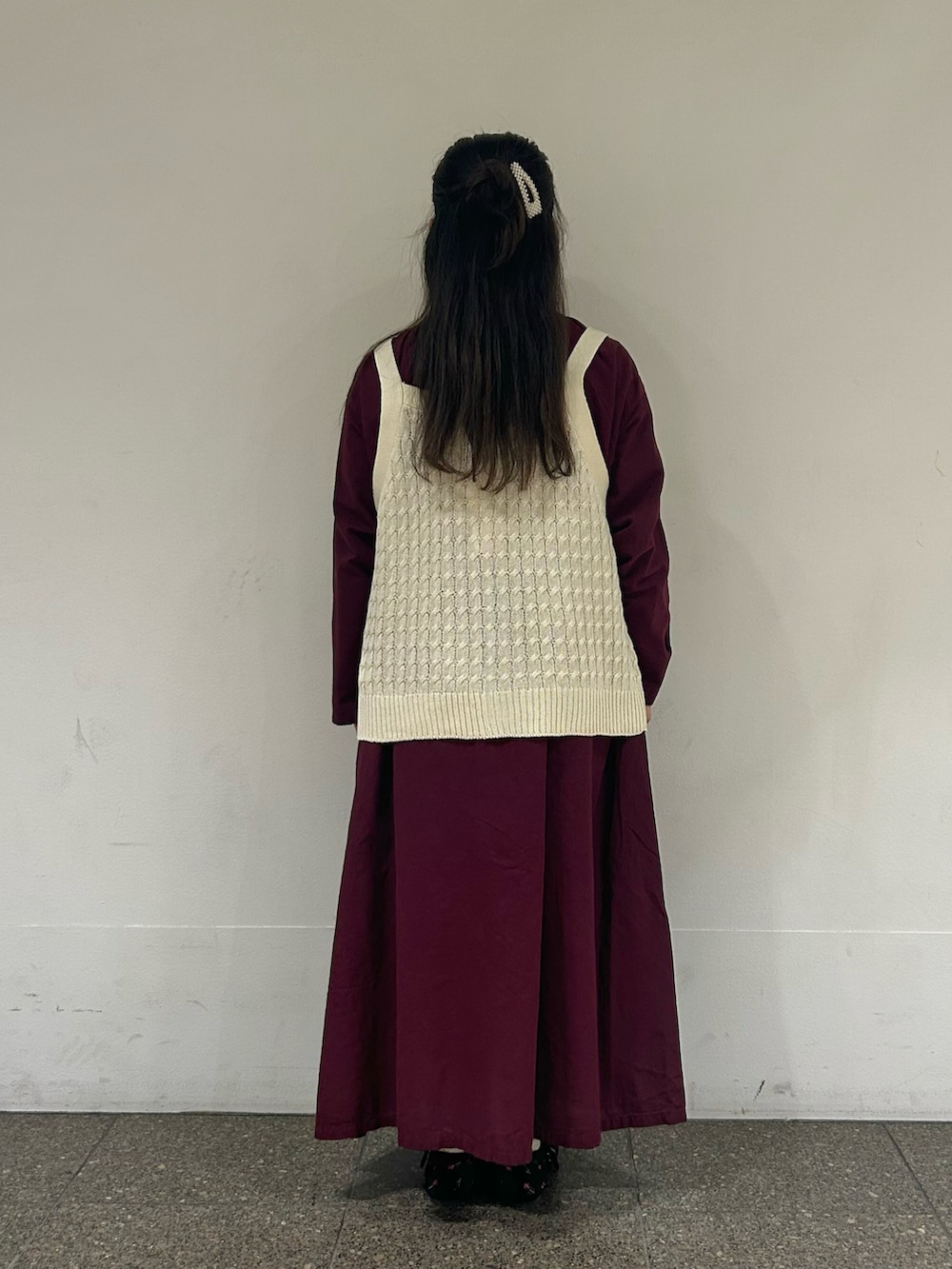 ホワイト系のベスト、パープル系のワンピース、ブラック系のドレスシューズを着用したレディースの秋コーディネートの3枚目の写真