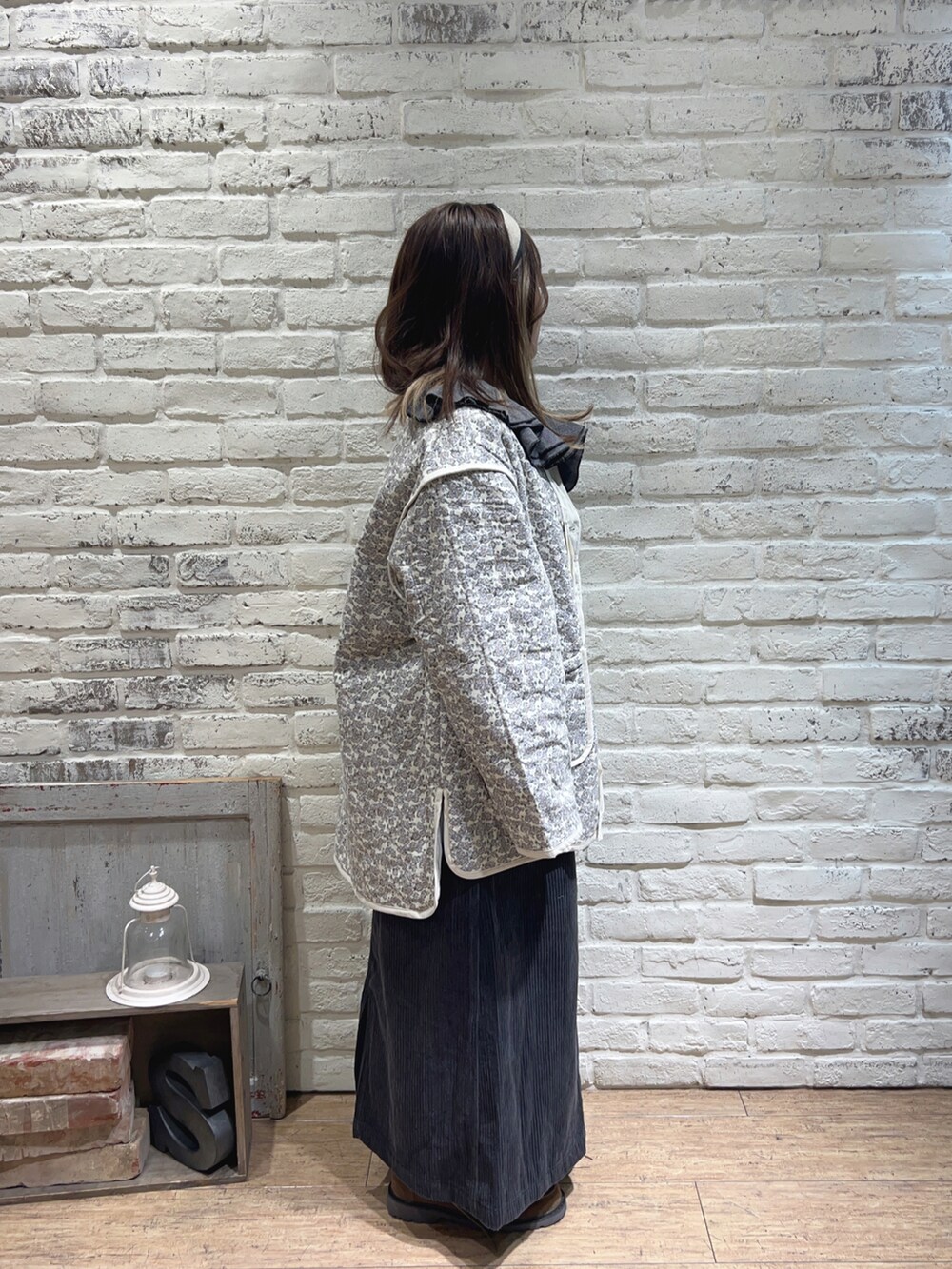 グレー系のシャツ/ブラウス、ブルー系のスカート、ホワイト系のノーカラージャケットを着用したレディースの秋コーディネートの2枚目の写真