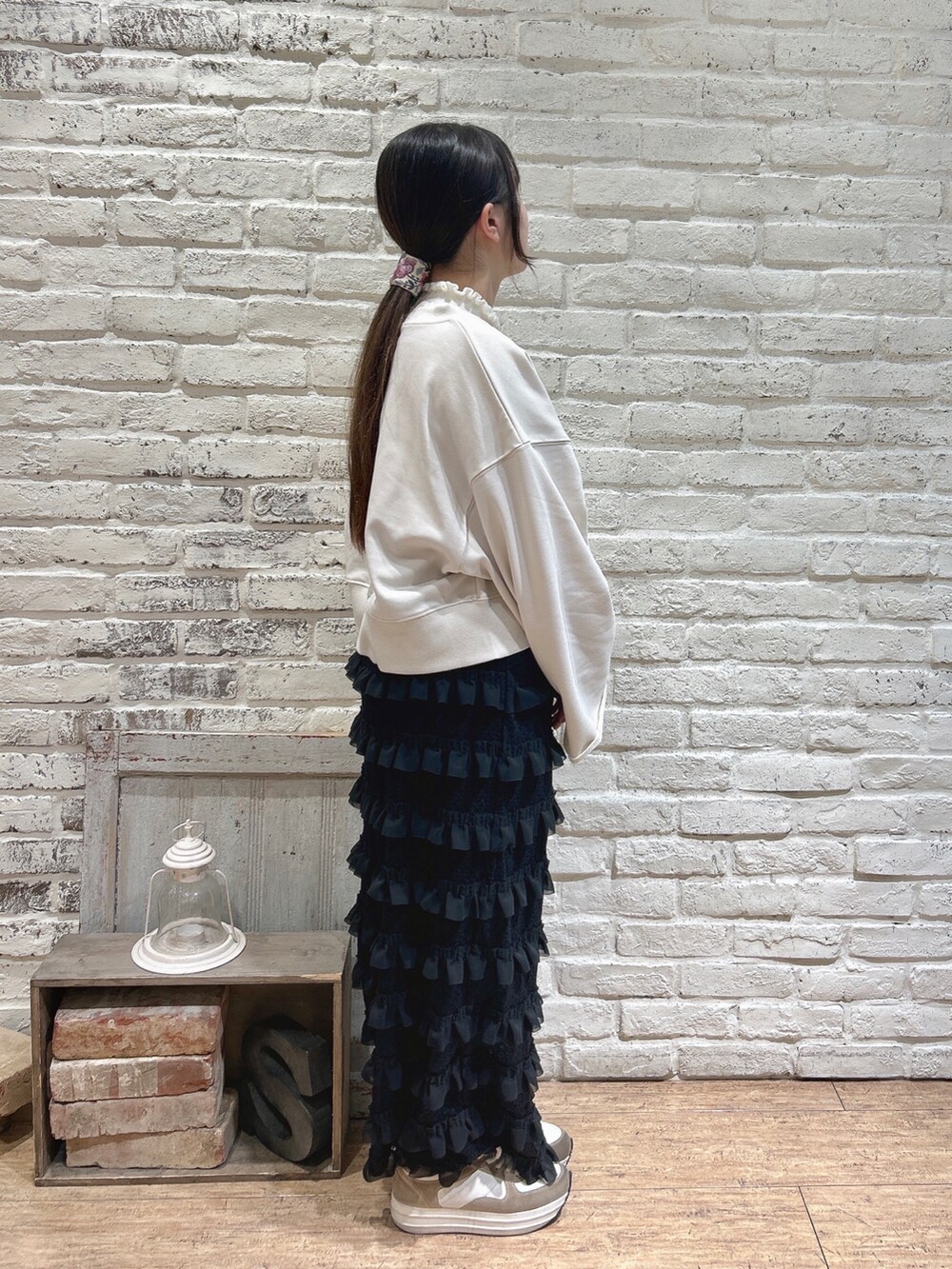 ブラック系のスカート、ホワイト系のTシャツ/カットソー、ブラック系のハンドバッグを着用したレディースの冬コーディネートの2枚目の写真