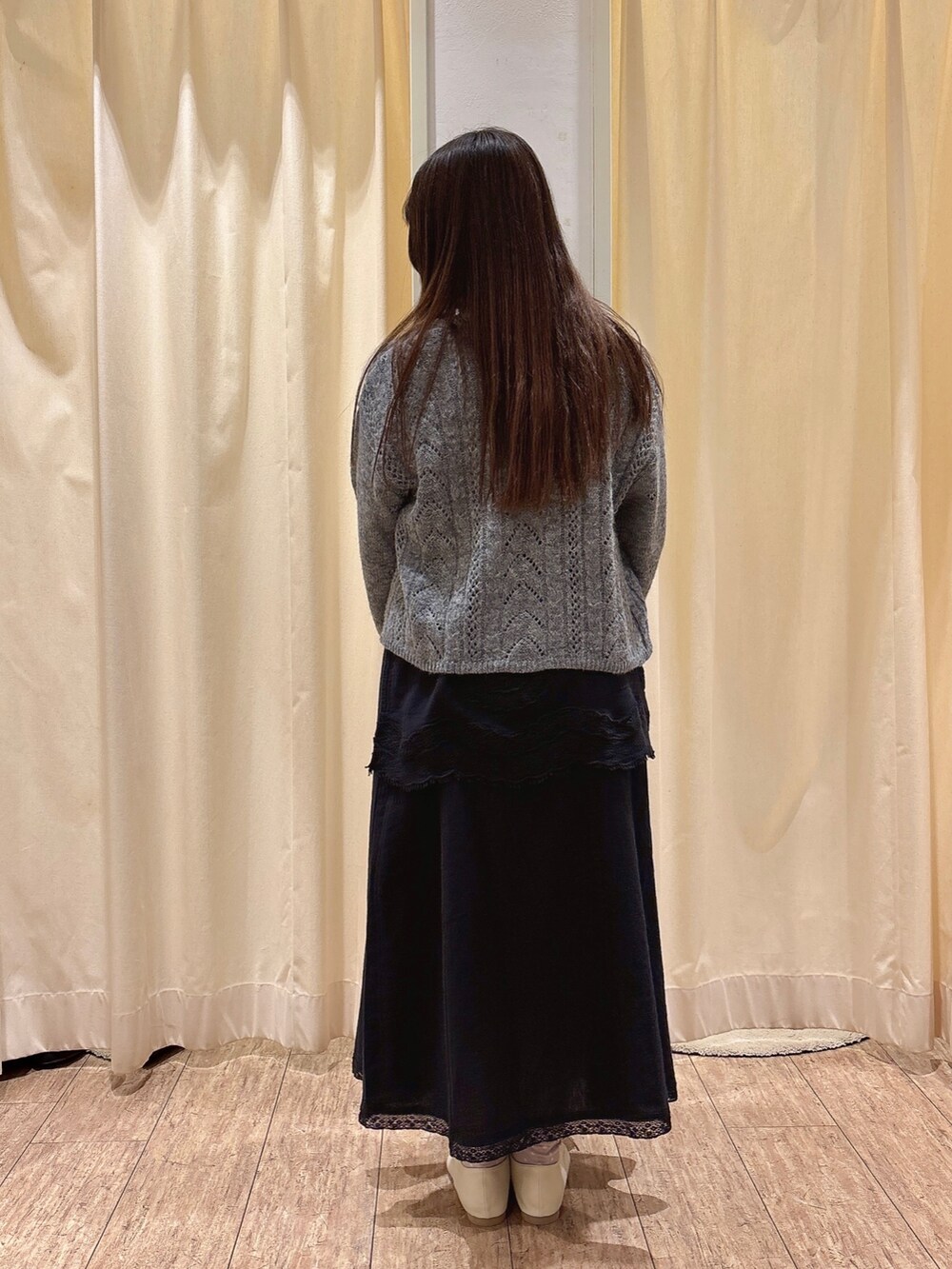 ベージュ系のハンドバッグ、グレー系のカーディガン/ボレロ、ホワイト系のニット/セーターを着用したレディースの秋コーディネートの3枚目の写真
