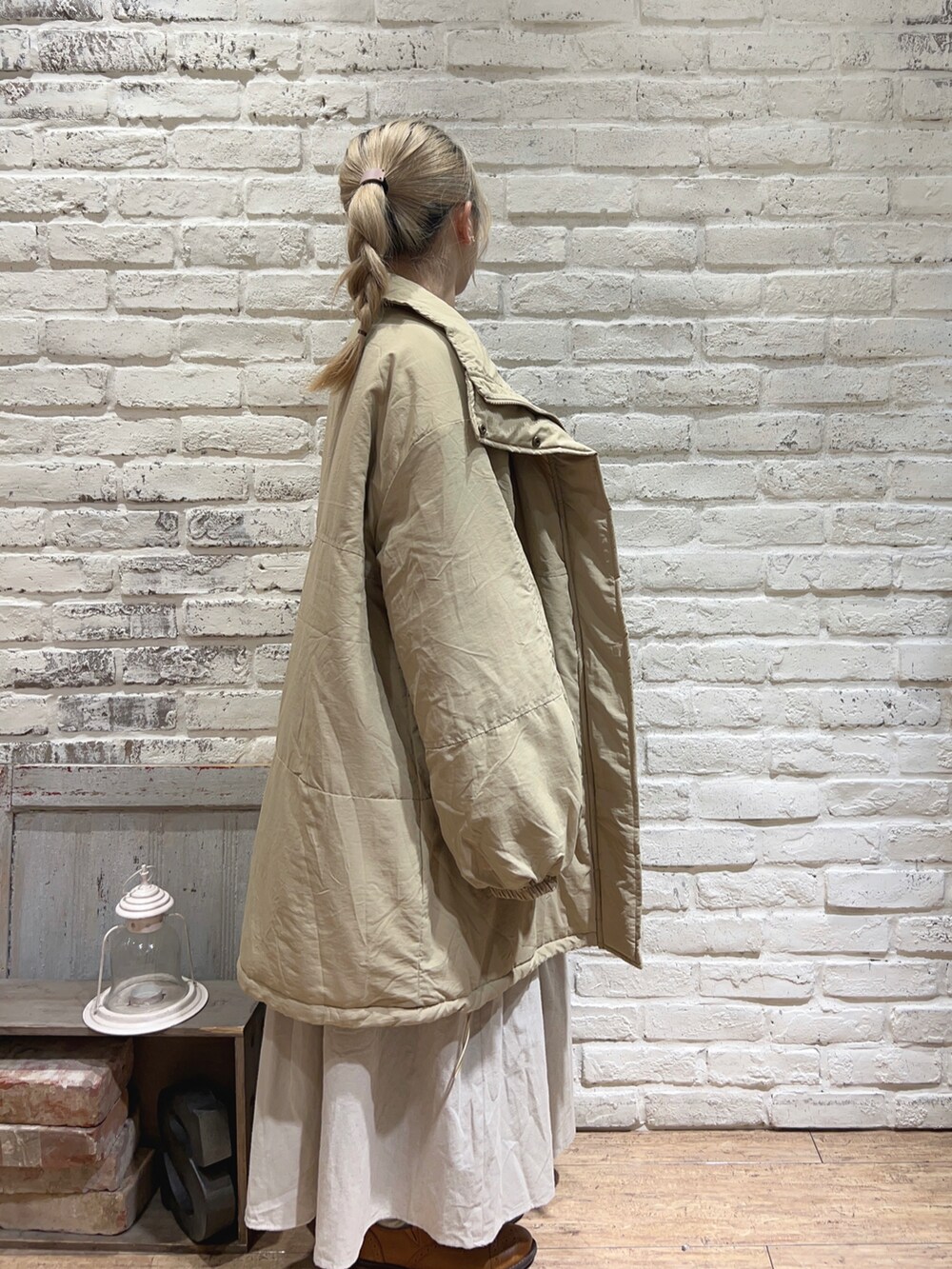 ベージュ系のその他アウター、グレー系のTシャツ/カットソー、ベージュ系のスカートを着用したレディースの冬コーディネートの2枚目の写真