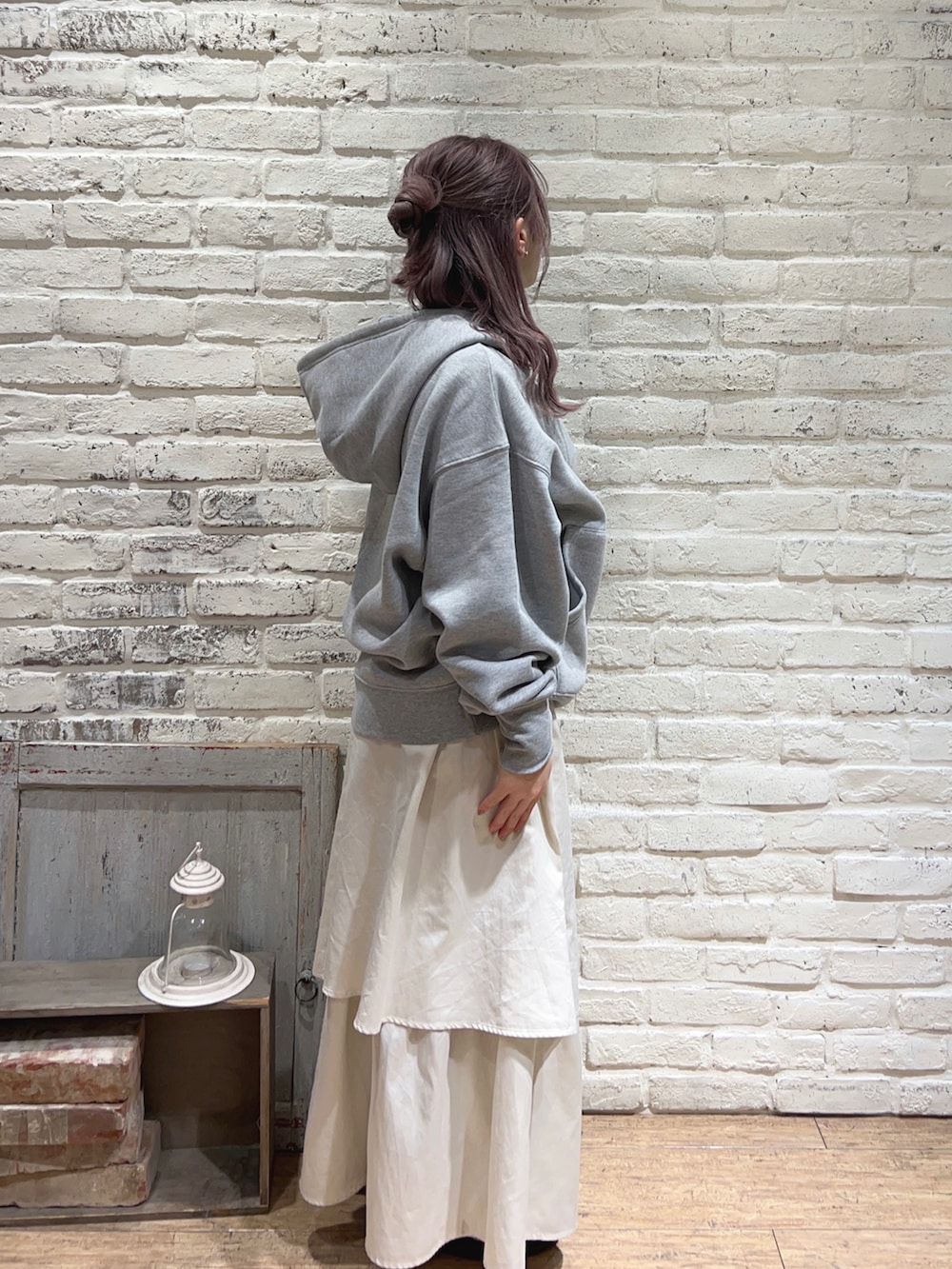 ホワイト系のスカート、グレー系のTシャツ/カットソーを着用したレディースの冬コーディネートの2枚目の写真