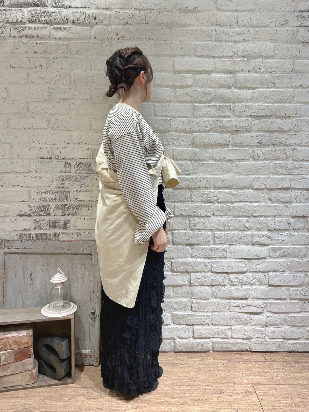 ブラック系のスカート、ホワイト系のTシャツ/カットソー、イエロー系のシャツ/ブラウスを着用したレディースの春コーディネートの2枚目の写真