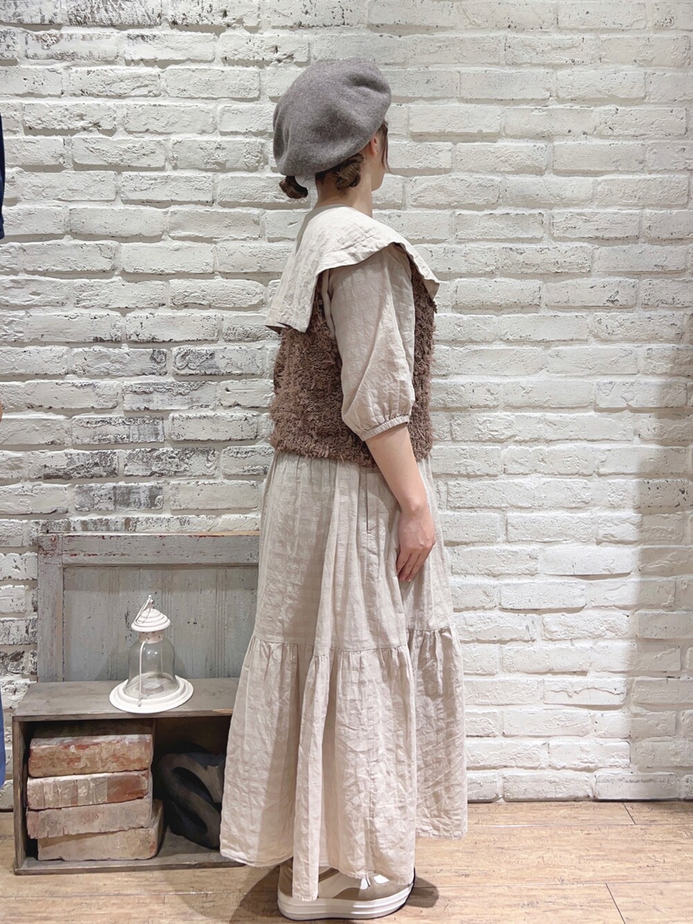 ベージュ系のワンピース、ブラウン系のベスト、ブラウン系のハットを着用したレディースの夏コーディネートの2枚目の写真