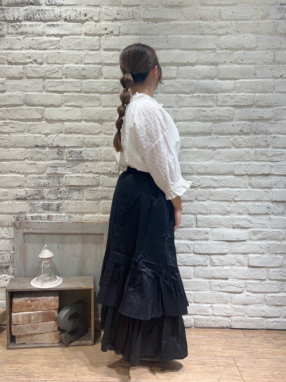 ホワイト系のTシャツ/カットソー、ブラック系のスカート、ブラック系のハンドバッグを着用したレディースの秋コーディネートの2枚目の写真