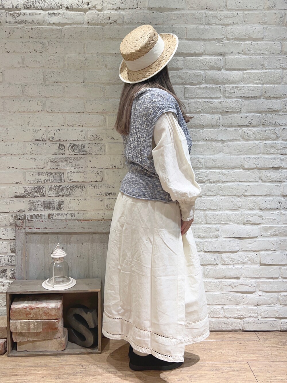 ブルー系のニット/セーター、ホワイト系のワンピースを着用したレディースの春コーディネートの2枚目の写真