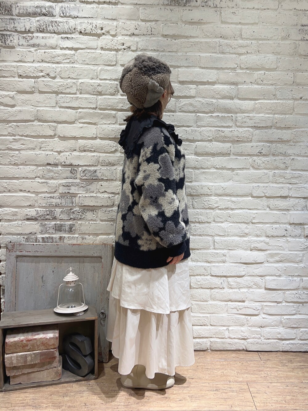 ホワイト系のスカート、ブラック系のシャツ/ブラウス、ブラック系のカーディガン/ボレロを着用したレディースの冬コーディネートの2枚目の写真