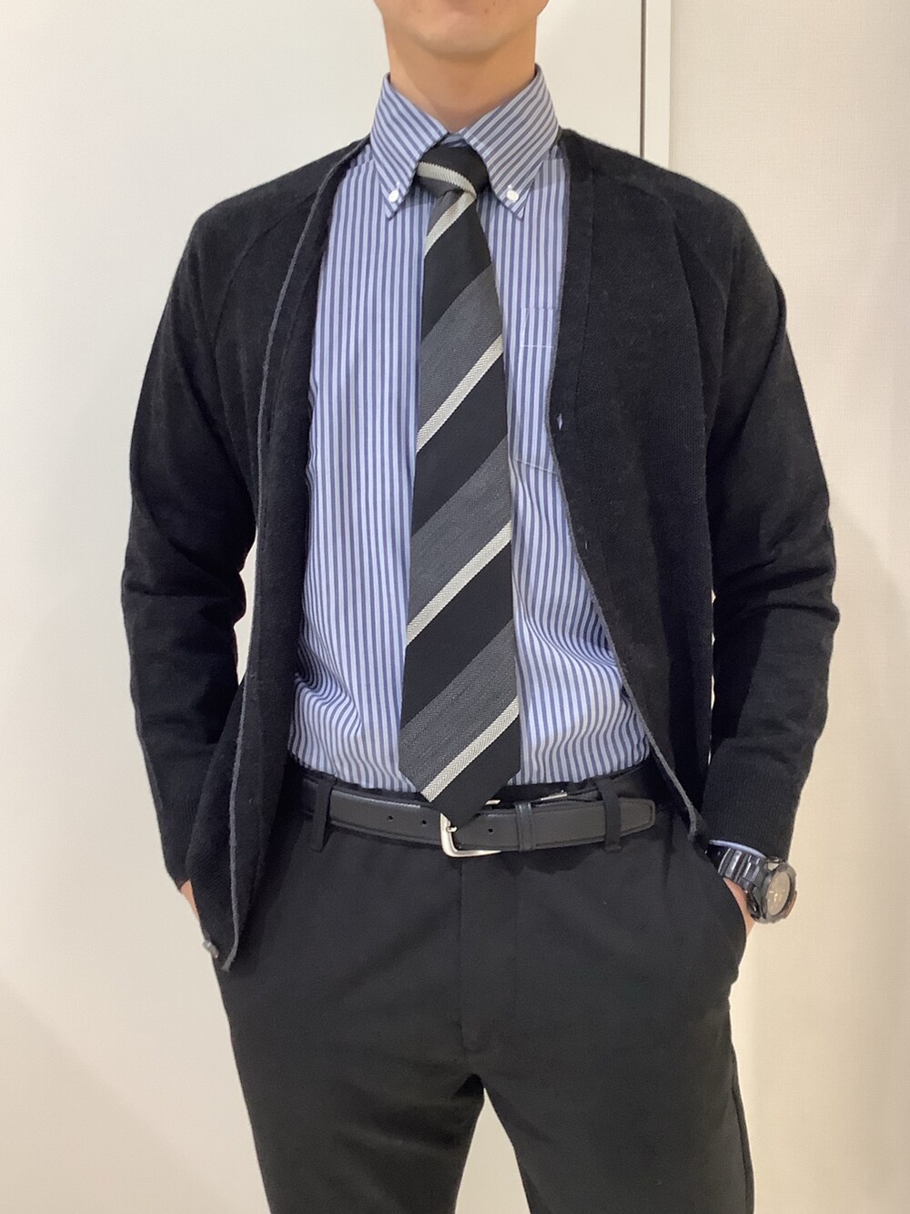 ブルー系のビジネスシャツ、ブラック系のカーディガン/ボレロ、ブラック系のネクタイを着用したメンズの冬コーディネートの2枚目の写真