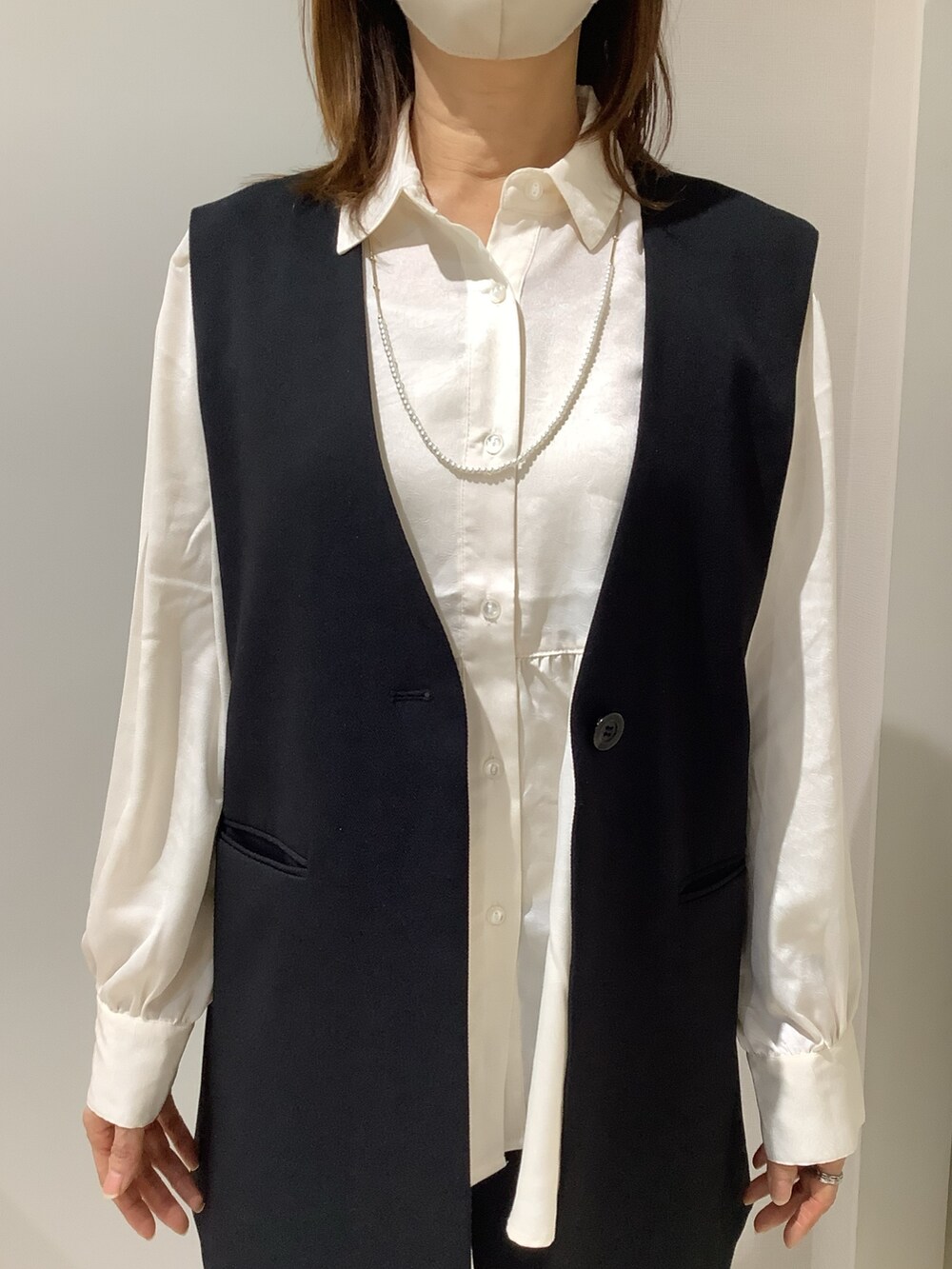 ホワイト系のシャツ/ブラウス、ブラック系のベストを着用したレディースの冬コーディネートの2枚目の写真