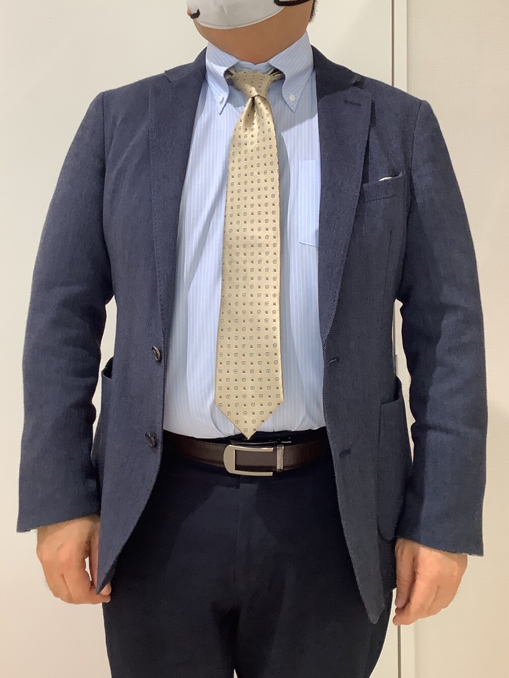 ブルー系のビジネスシャツ、ベージュ系のネクタイを着用したメンズの冬コーディネートの2枚目の写真