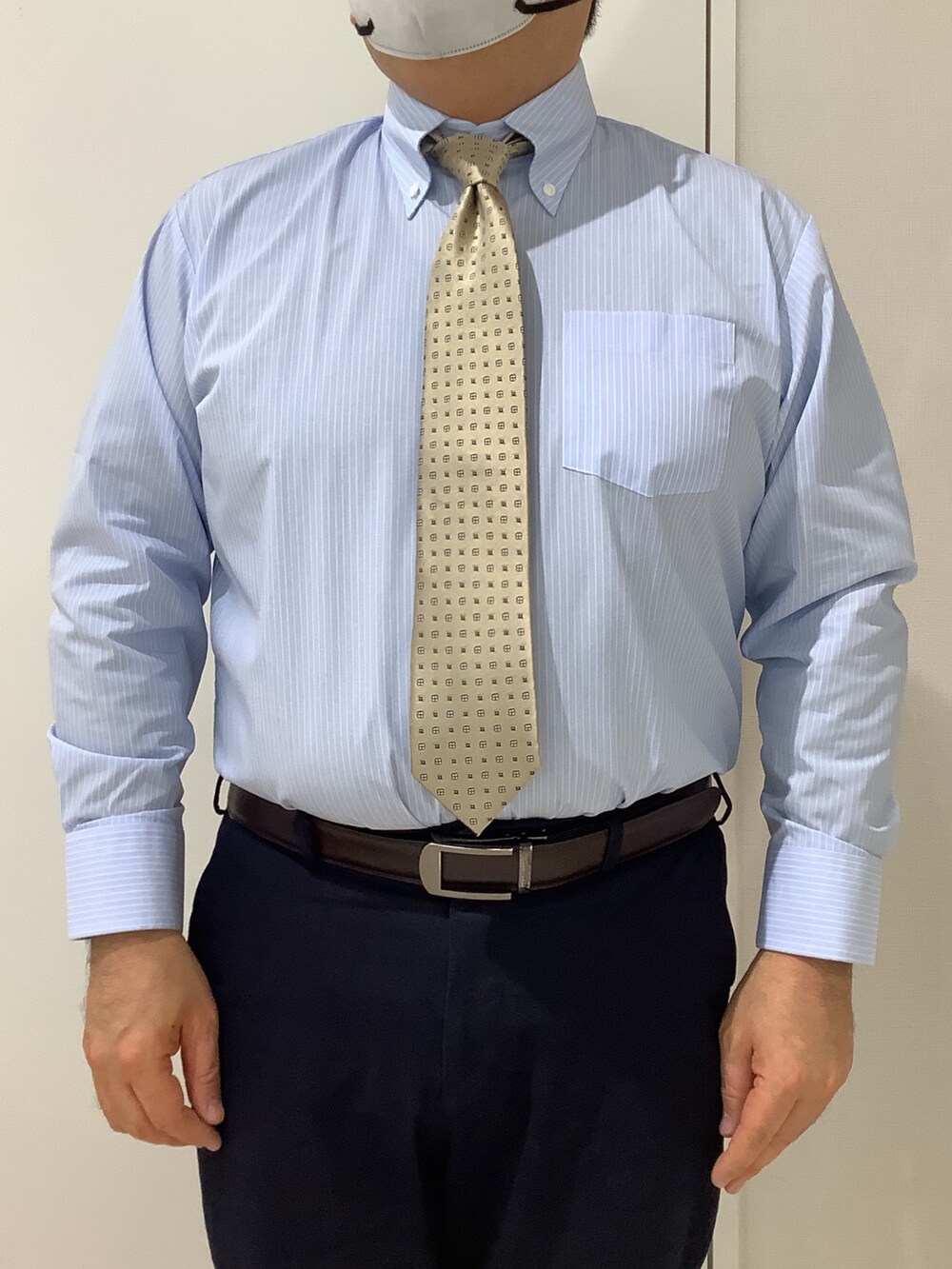 ブルー系のビジネスシャツ、ベージュ系のネクタイを着用したメンズの冬コーディネートの3枚目の写真