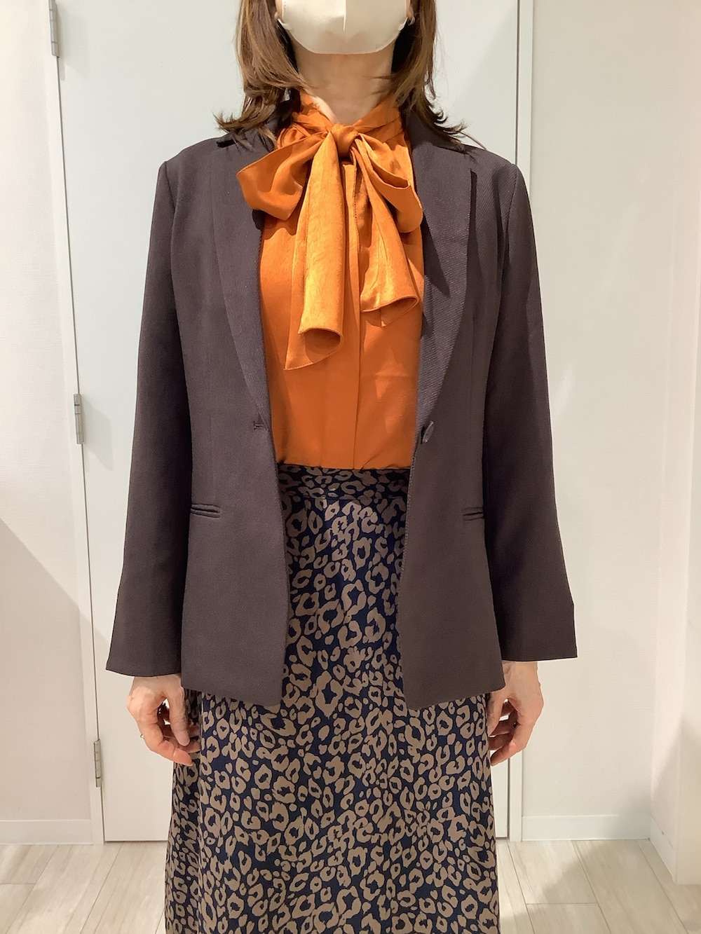ブラウン系のテーラードジャケット、オレンジ系のシャツ/ブラウスを着用したレディースの秋コーディネートの2枚目の写真