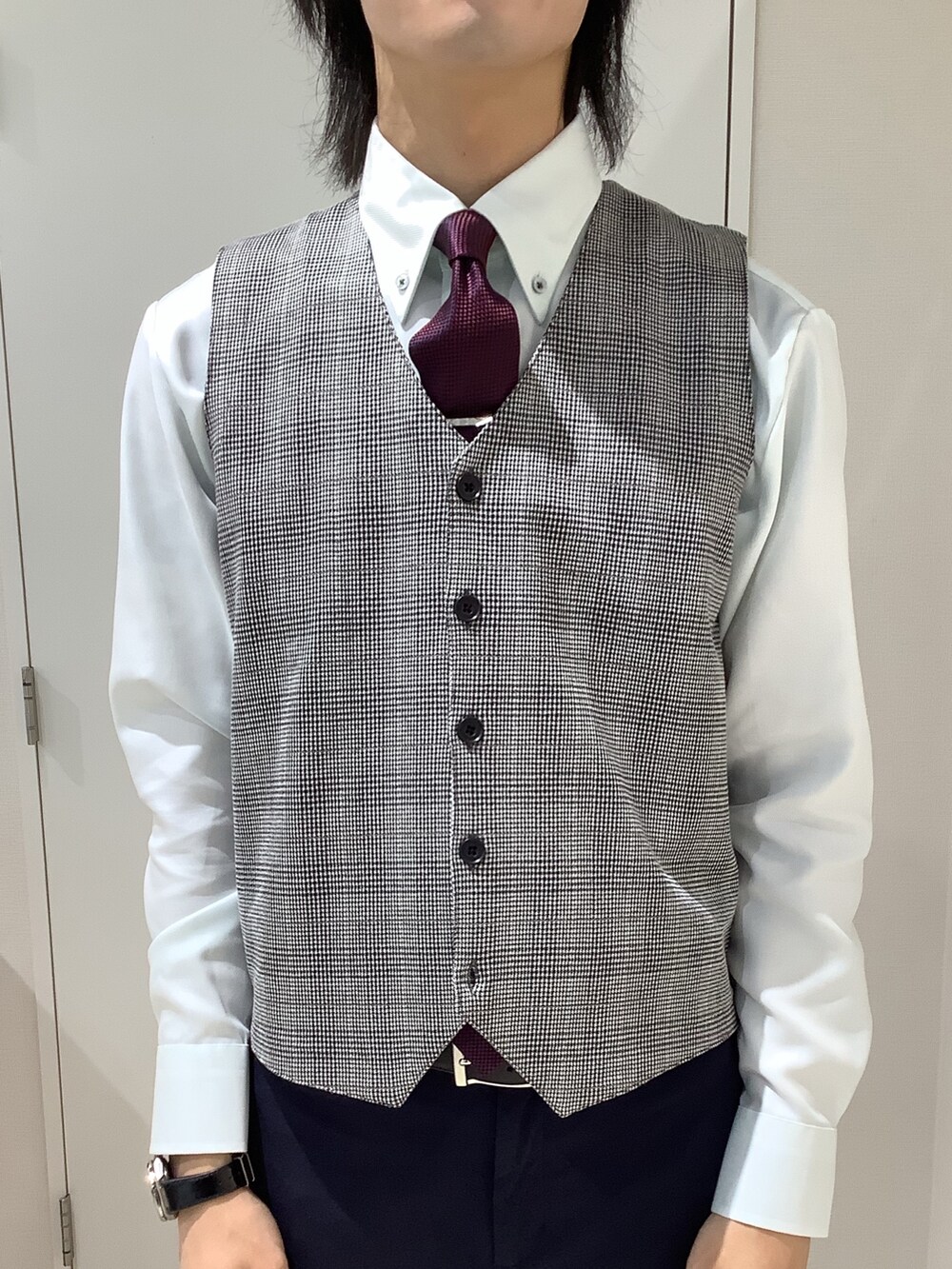 グリーン系のビジネスシャツ、グレー系のベストを着用したメンズの秋コーディネートの2枚目の写真