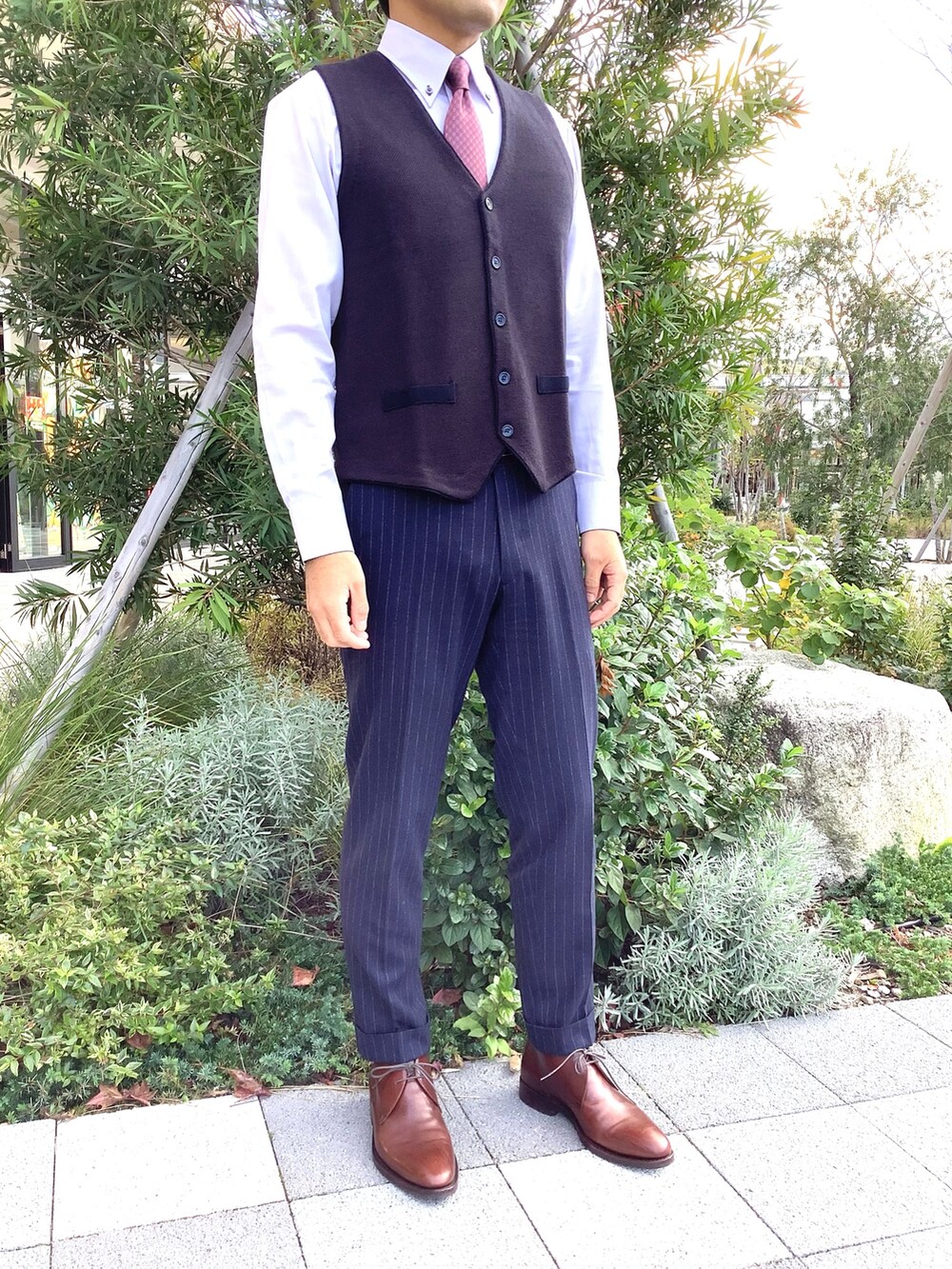 グレー系のビジネスシャツ、グレー系のベストを着用したメンズの冬コーディネートの2枚目の写真