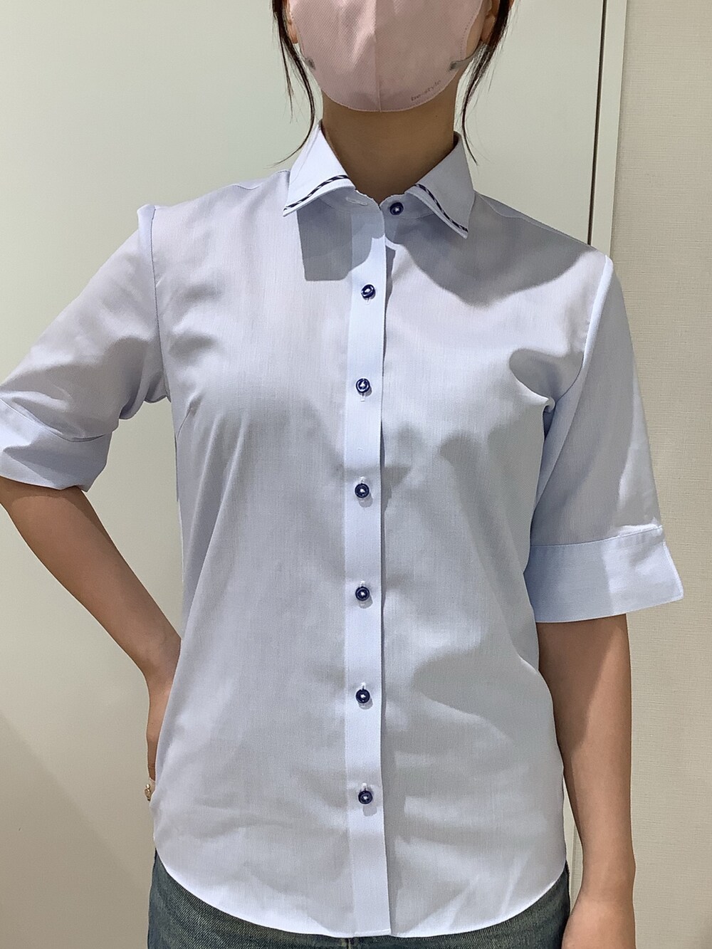 ブルー系のビジネスシャツを着用したレディースの夏コーディネートの2枚目の写真