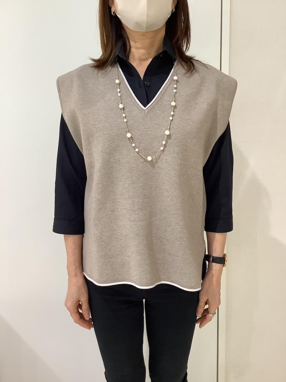 ブラック系のビジネスシャツを着用したレディースの春コーディネートの2枚目の写真