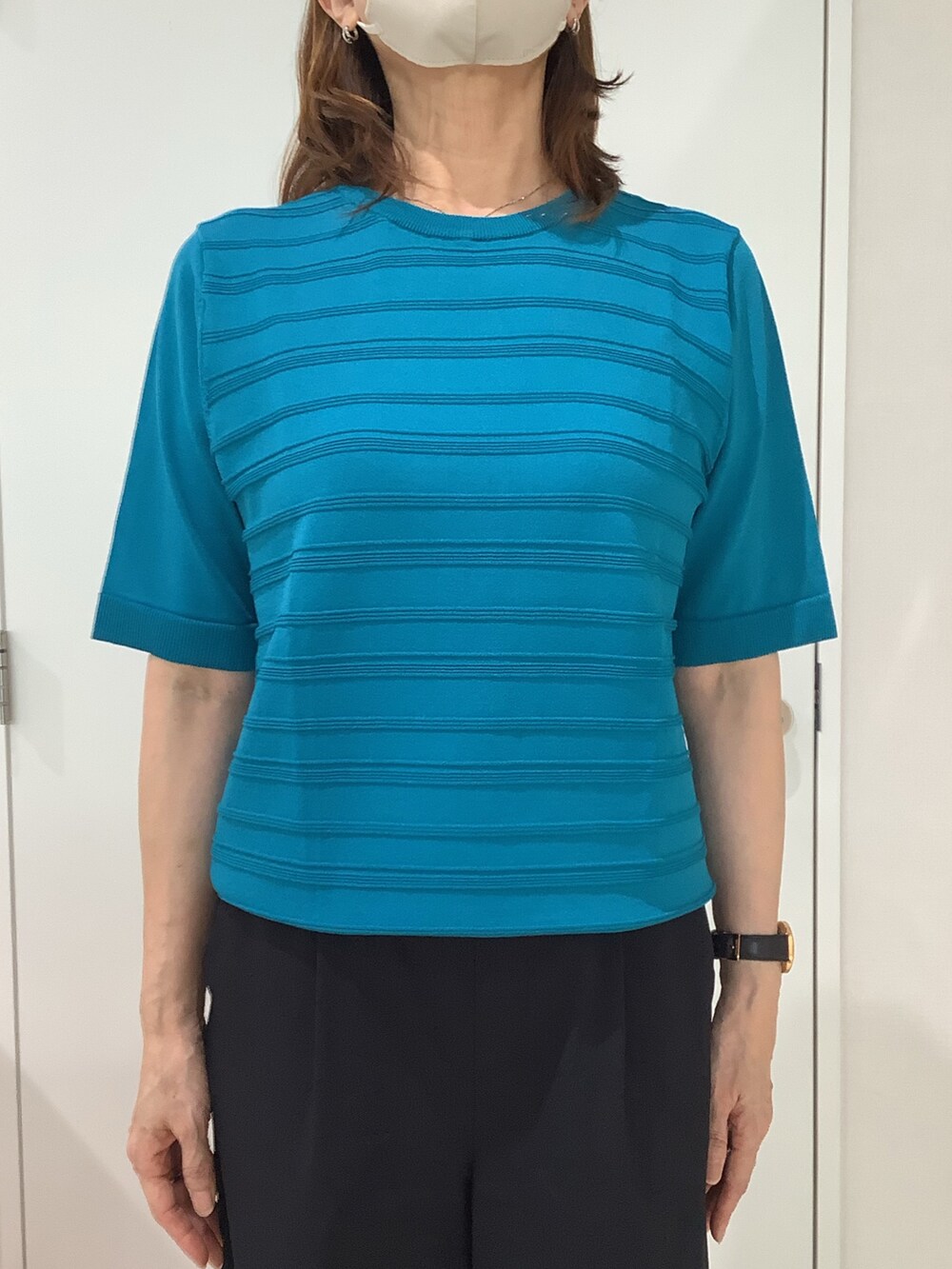 ブルー系のニット/セーターを着用したレディースの夏コーディネートの2枚目の写真