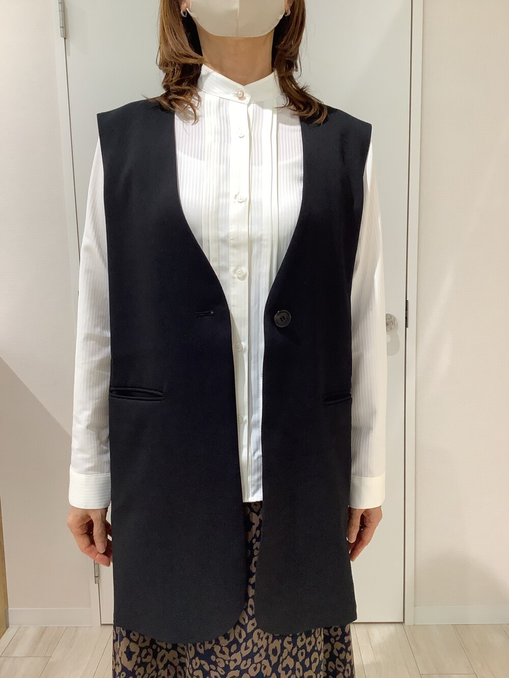 ブラック系のベスト、ホワイト系のシャツ/ブラウスを着用したレディースの秋コーディネートの2枚目の写真