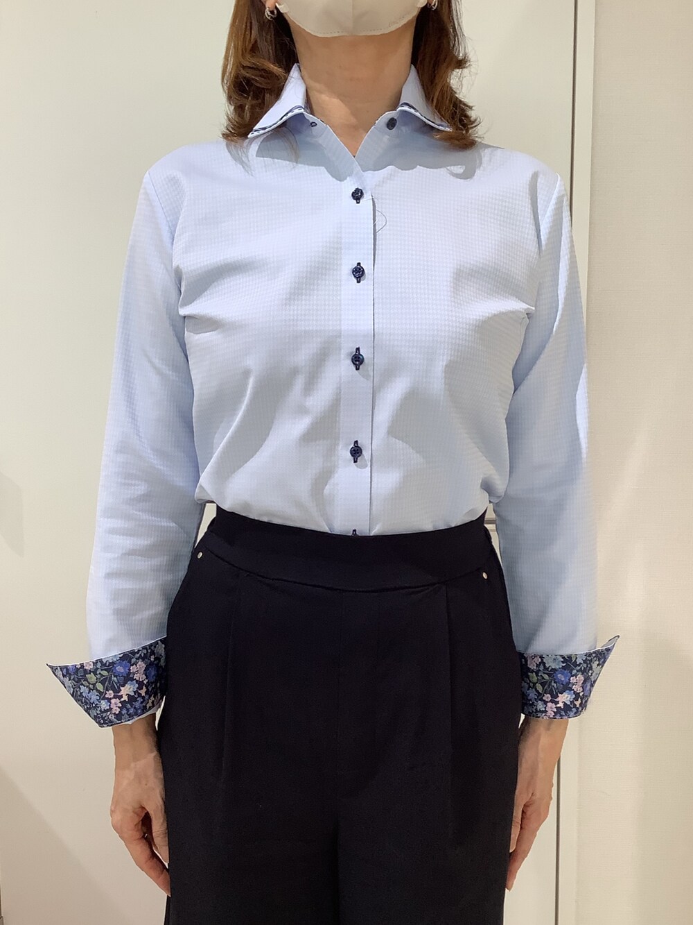 ブルー系のビジネスシャツを着用したレディースの夏コーディネートの2枚目の写真