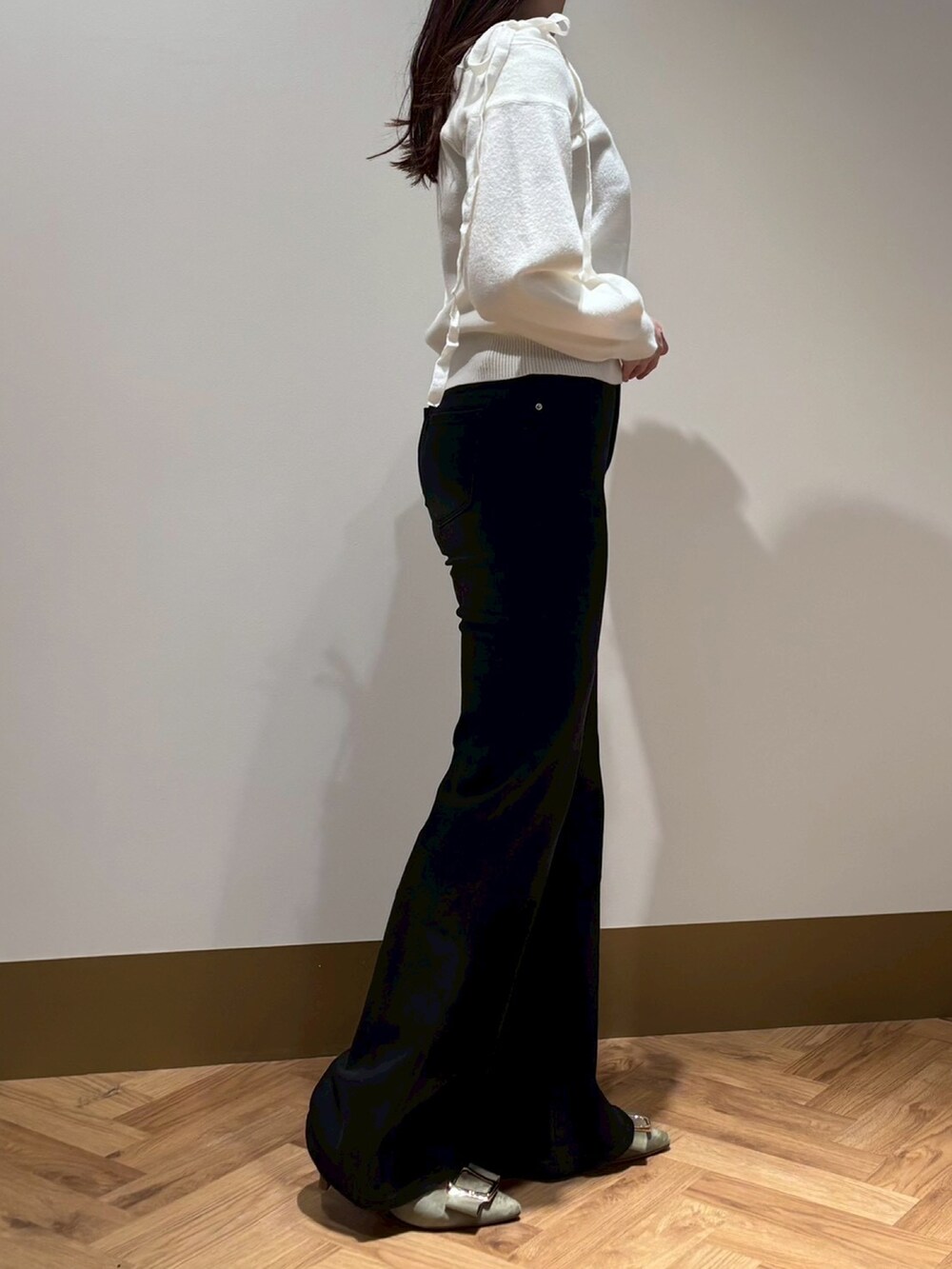 ホワイト系のニット/セーター、ブラック系のその他パンツを着用したレディースの春コーディネートの2枚目の写真