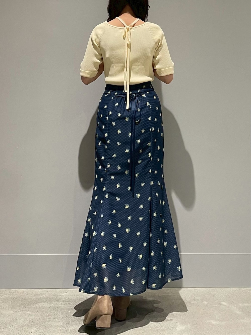 ブルー系のスカート、イエロー系のニット/セーターを着用したレディースの春コーディネートの3枚目の写真