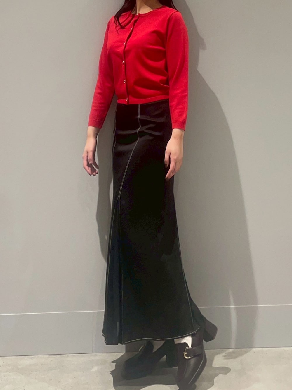 レッド系のカーディガン/ボレロ、ブラック系のスカートを着用したレディースの冬コーディネートの2枚目の写真