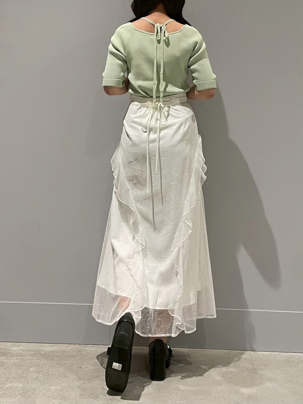 ホワイト系のスカート、イエロー系のニット/セーターを着用したレディースの春コーディネートの3枚目の写真