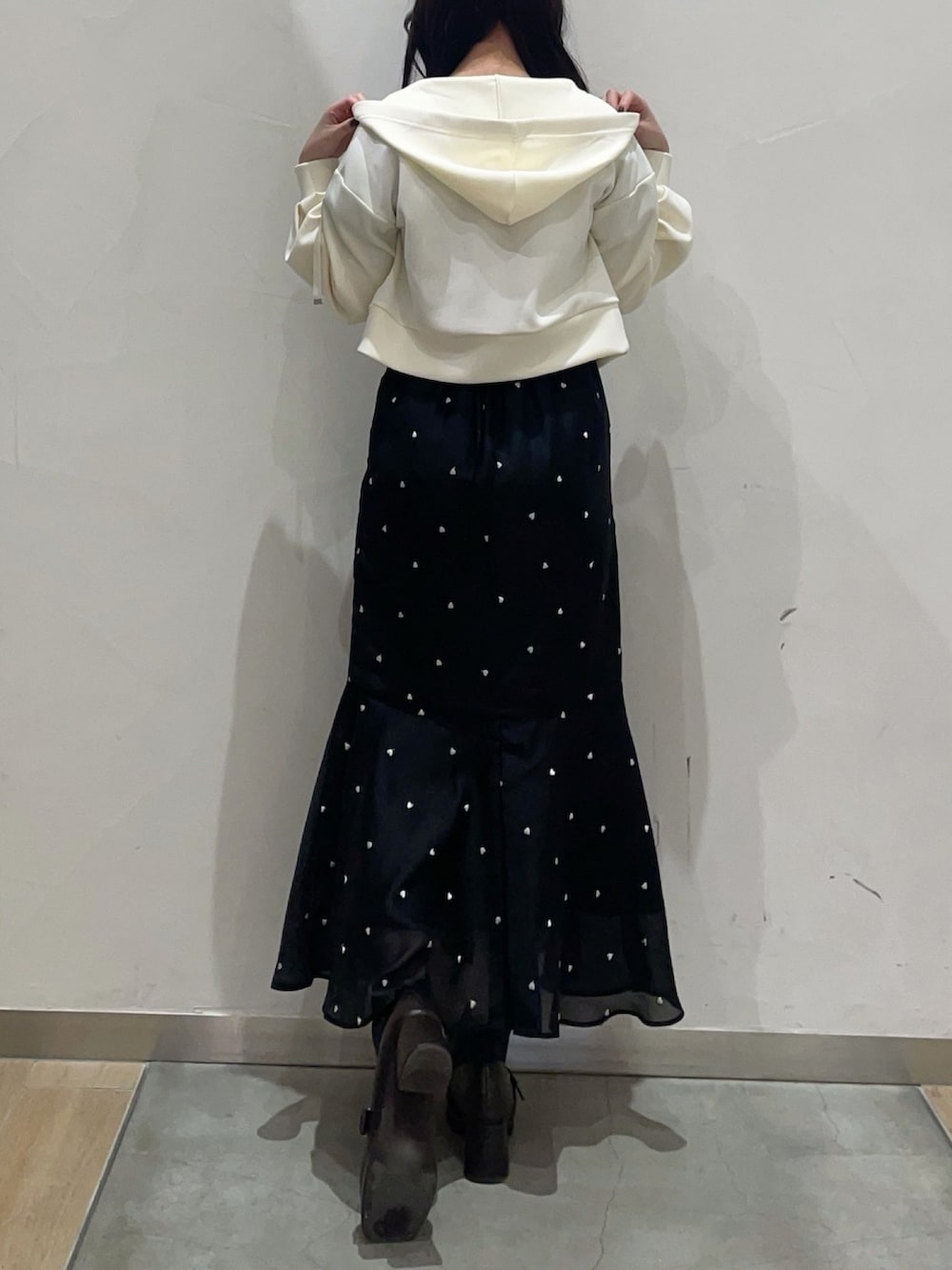 イエロー系のパーカー、ブラック系のワンピースを着用したレディースの冬コーディネートの3枚目の写真