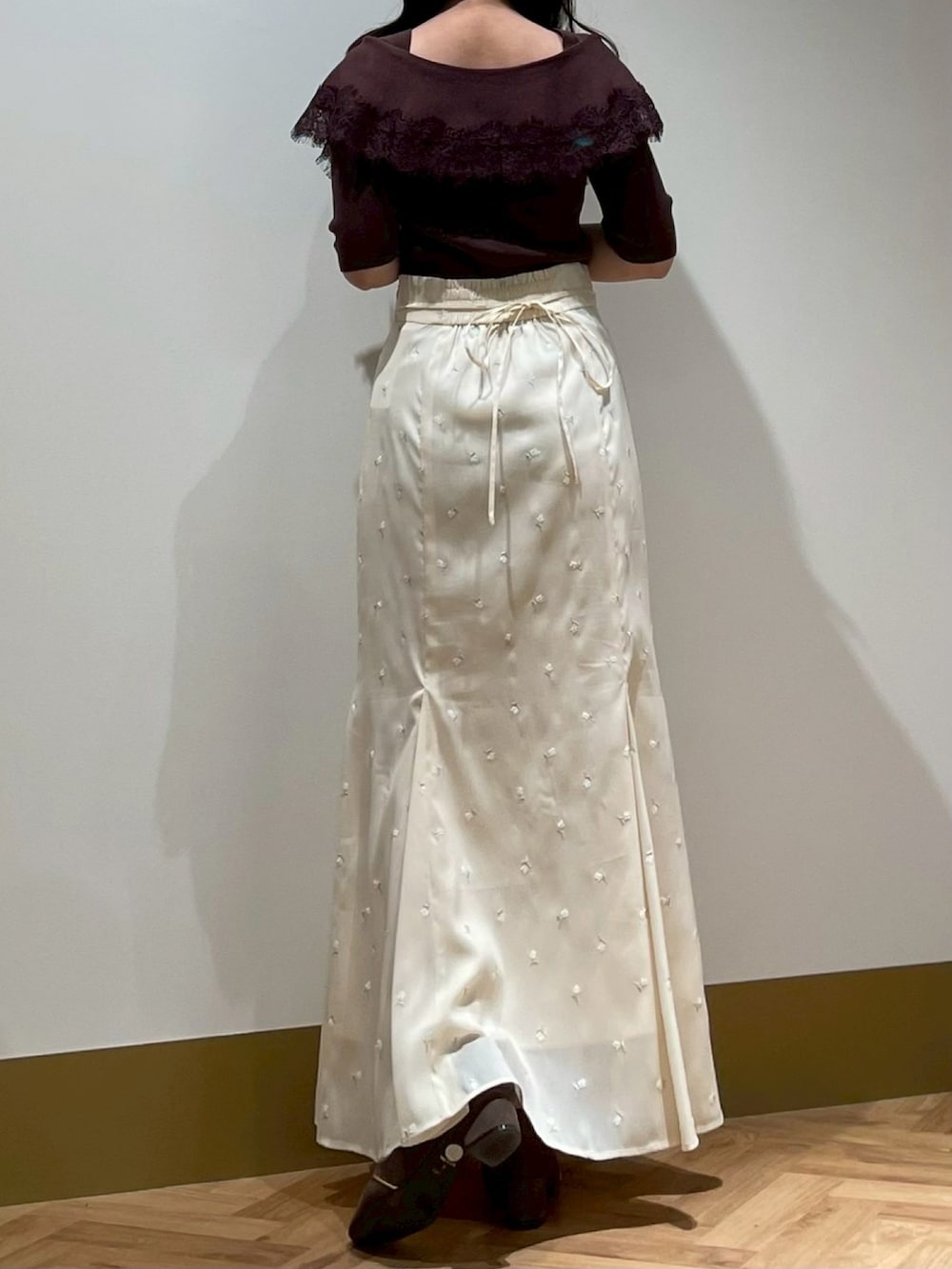 イエロー系のスカート、ブラウン系のニット/セーターを着用したレディースの春コーディネートの3枚目の写真