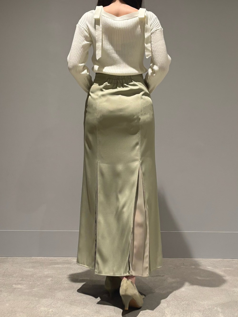 グリーン系のスカート、ブルー系のニット/セーターを着用したレディースの春コーディネートの3枚目の写真