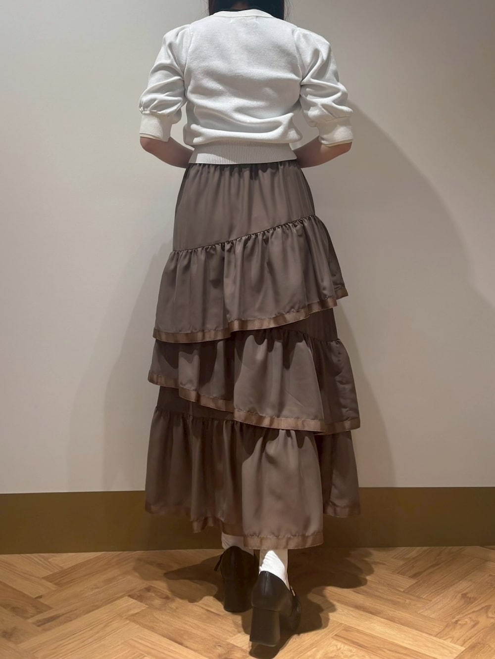ブラウン系のスカート、ホワイト系のカーディガン/ボレロを着用したレディースの春コーディネートの3枚目の写真