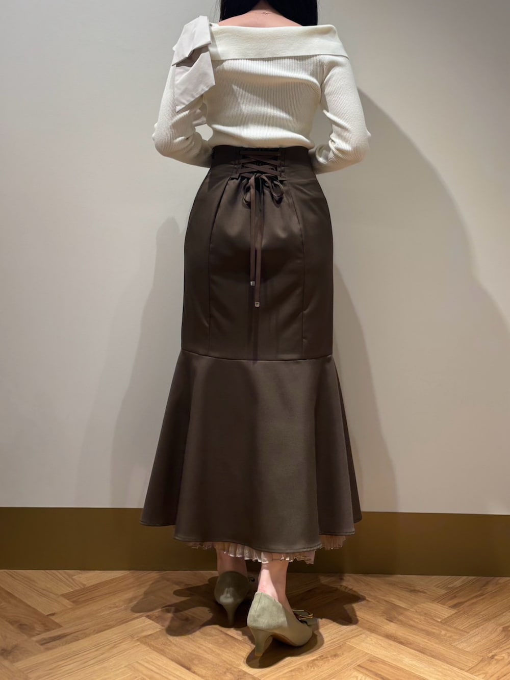 ホワイト系のニット/セーター、ブラウン系のスカートを着用したレディースの春コーディネートの2枚目の写真