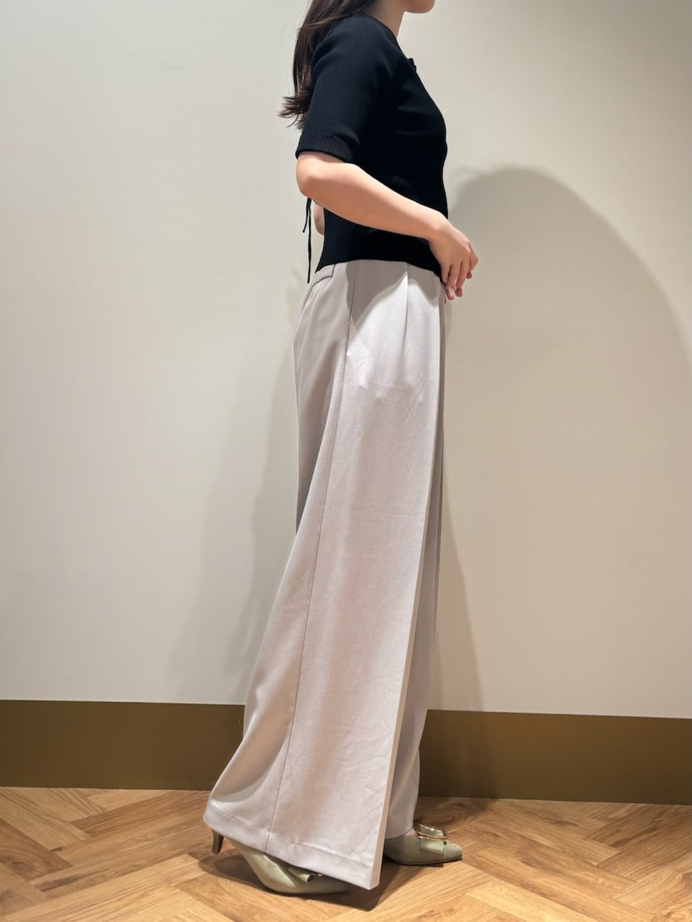 イエロー系のニット/セーター、グレー系のその他パンツを着用したレディースの春コーディネートの2枚目の写真