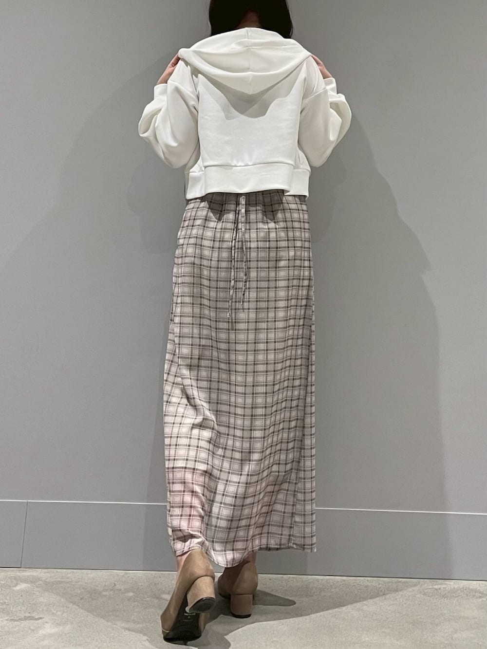 グリーン系のワンピース、ホワイト系のパーカーを着用したレディースの春コーディネートの3枚目の写真